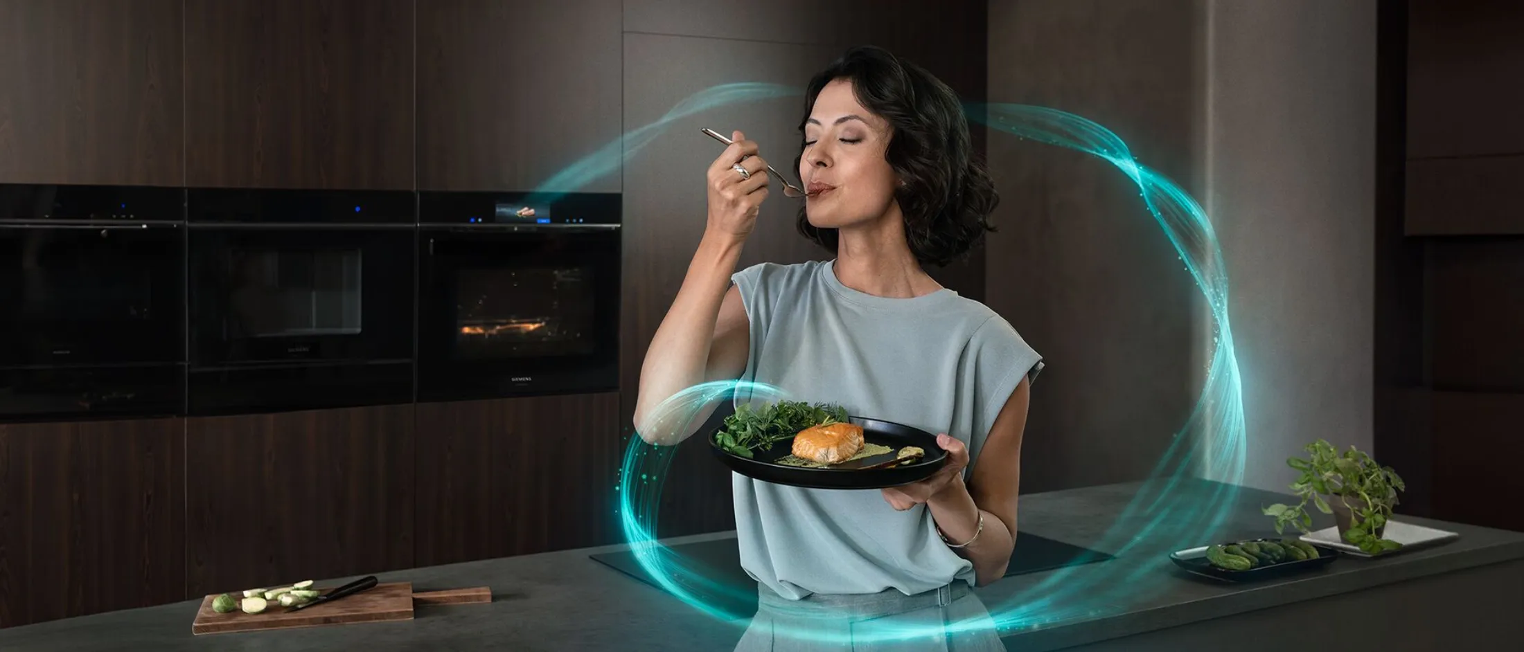 Donna che si gode un pasto in una moderna cucina intelligente, con linee blu luminose che simboleggiano la connettività e le funzionalità avanzate degli elettrodomestici.