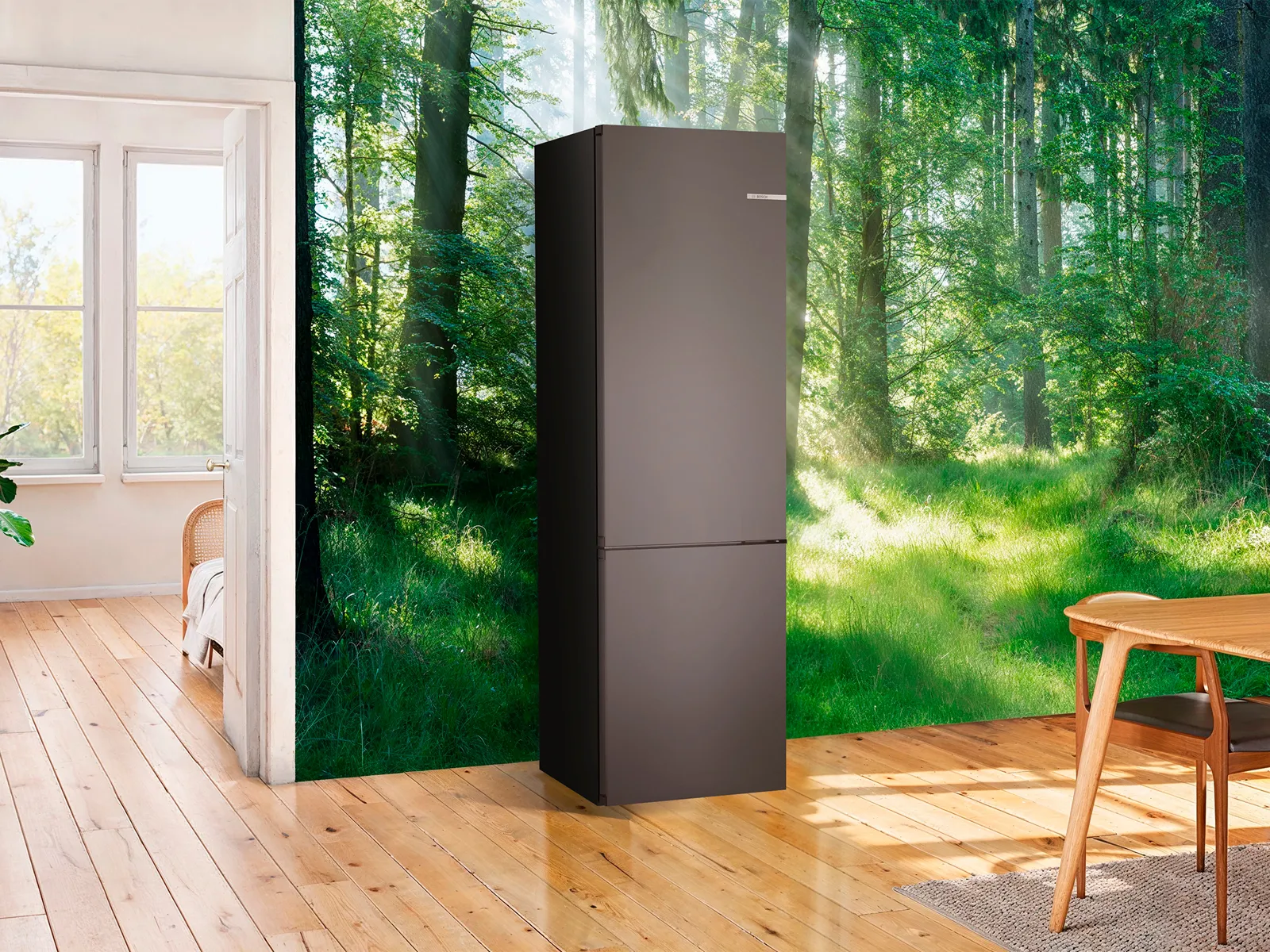Heldere, luchtige keuken met houten vloeren, grote ramen met uitzicht op een weelderige bos, en een zwarte koelkast.