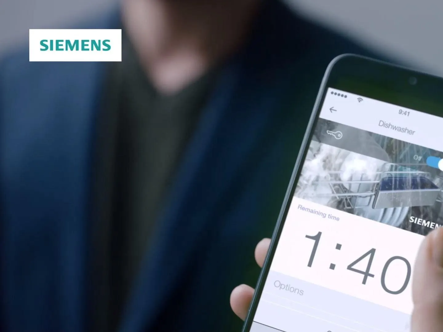 Obrázok zobrazuje osobu, ktorá drží smartfón s logom Siemens a časom 1:40.