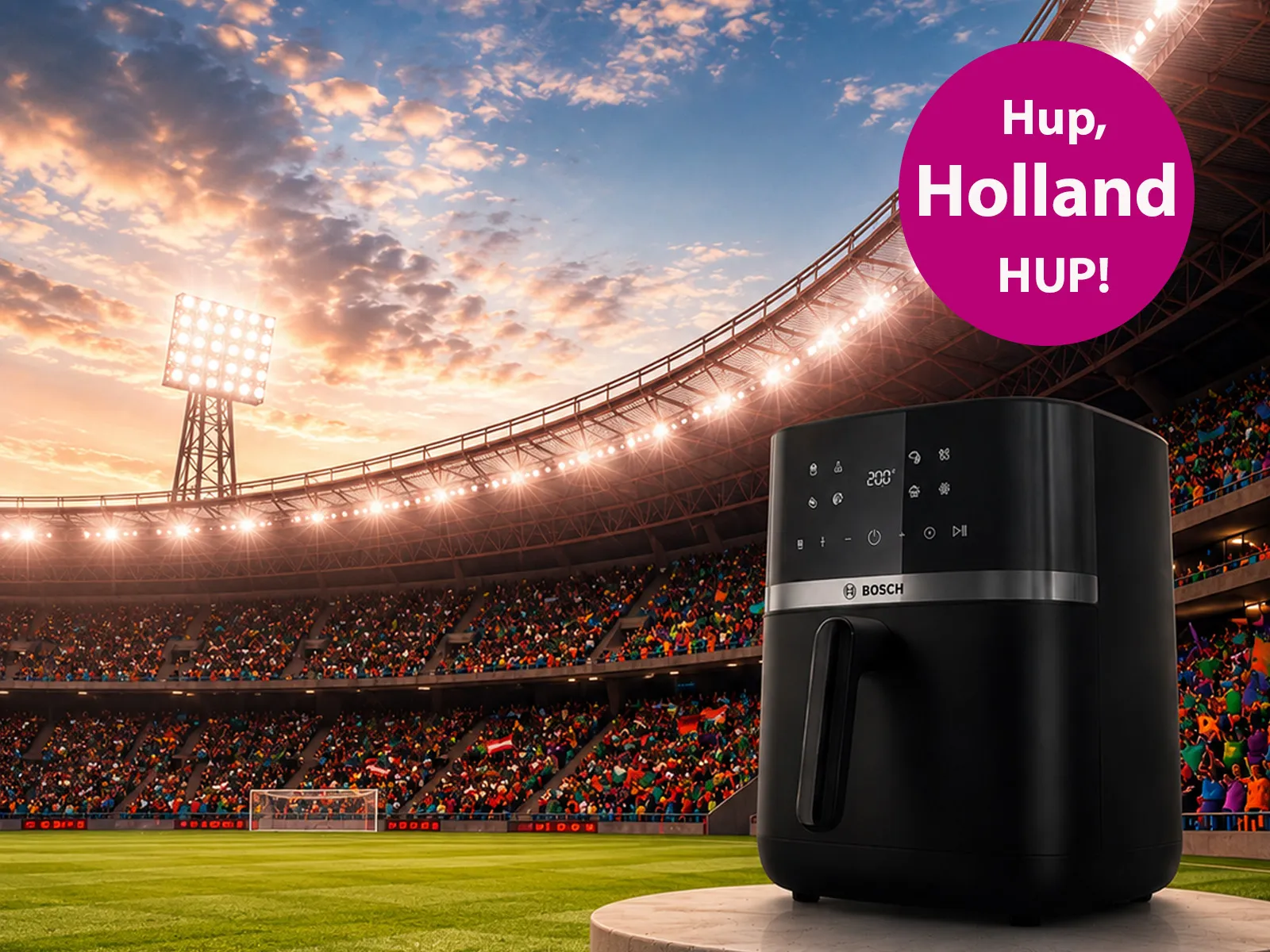 Zwarte Bosch-airfryer op een sokkel in een stadion, met een juichend publiek en een zonsondergang op de achtergrond, voorzien van de tekst "Hup, Holland HUP!".