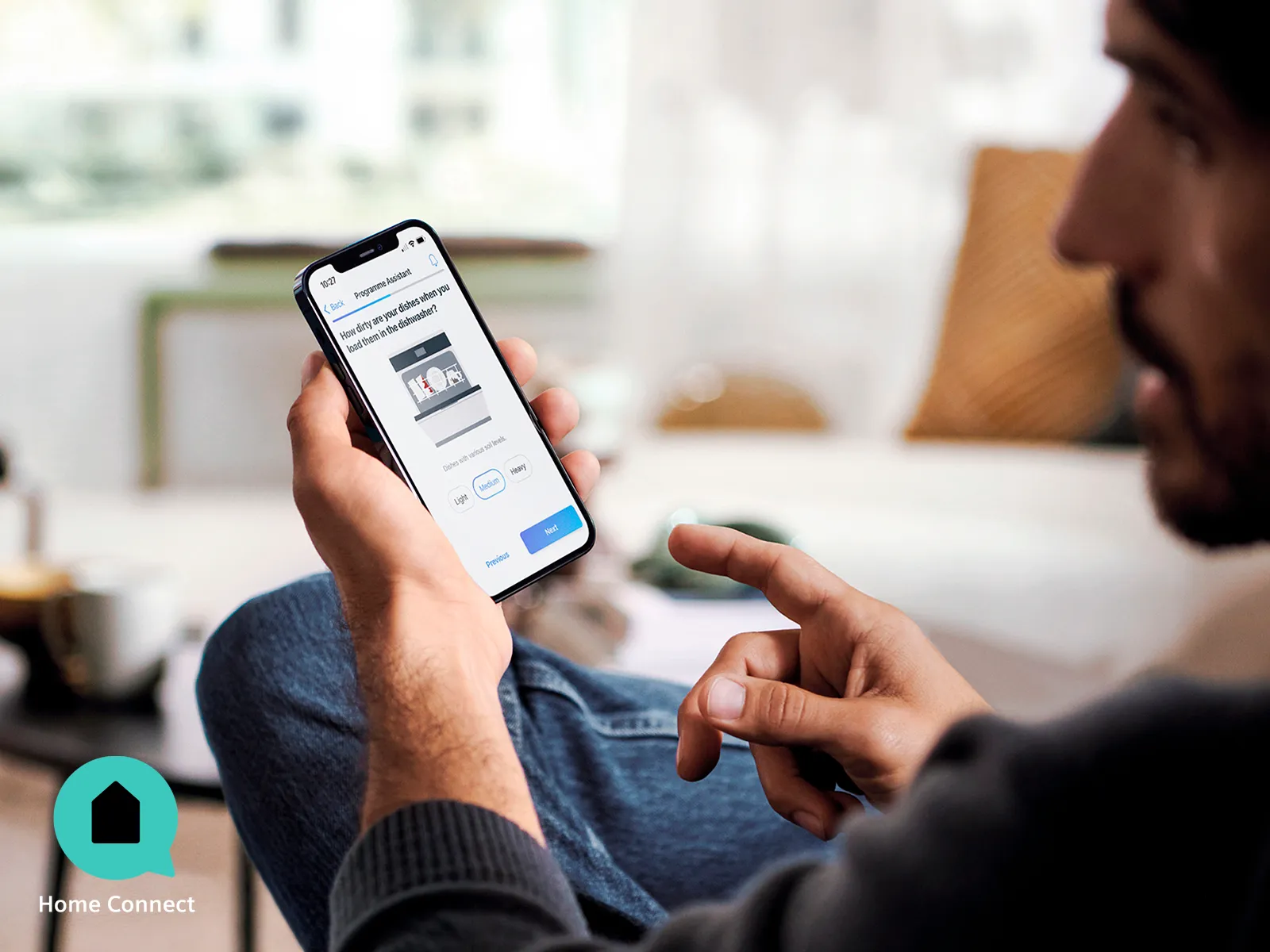Person using smartphone app on couch in living room.