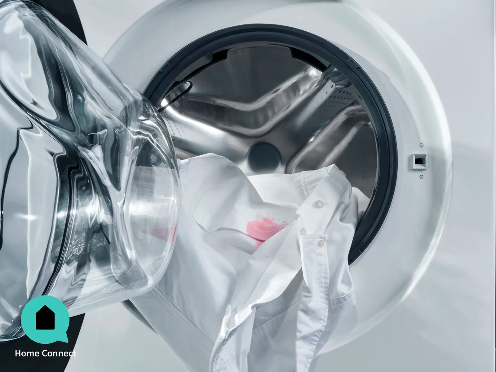 Cestello della lavatrice con capi d'abbigliamento e detersivo, e oblò aperto che ne mostra l'interno.