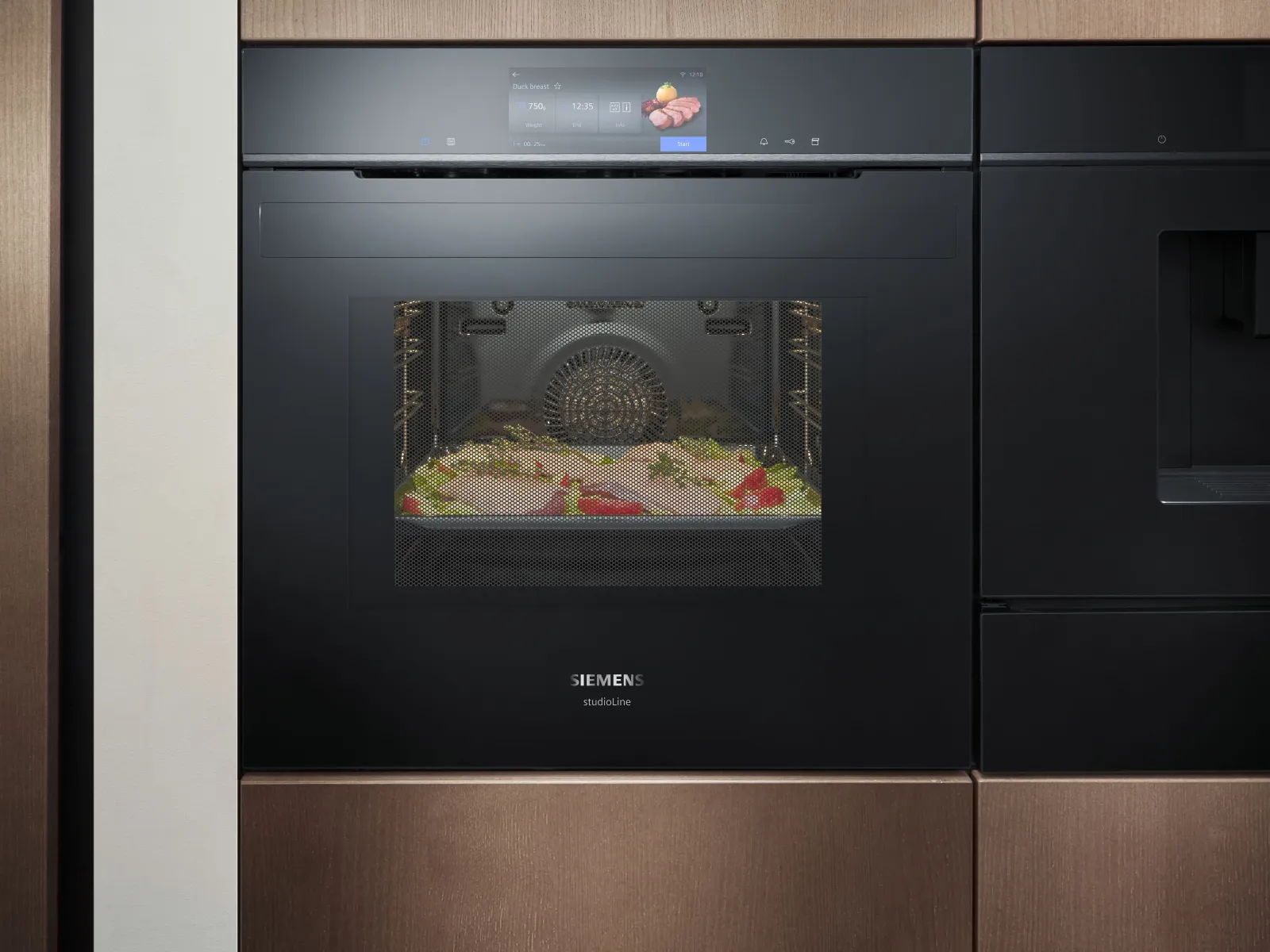 Built-in Siemens black oven with digital display cooking duck breast, showing time, temperature, and start button.