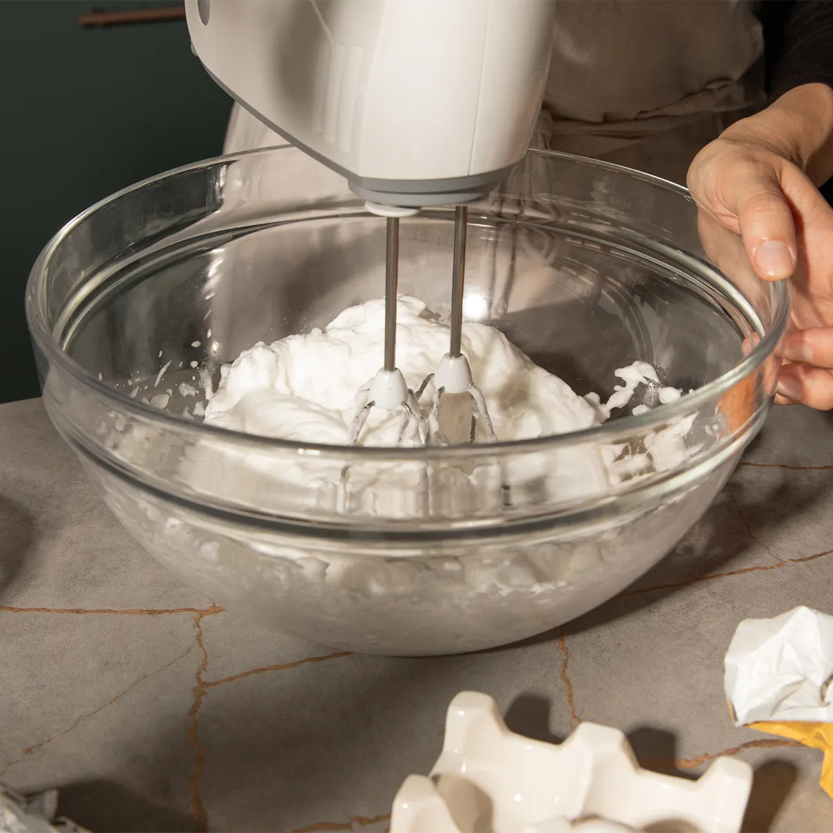Whipping fluffy cream in a glass bowl with a hand mixer. Neff makes baking effortless and enjoyable.