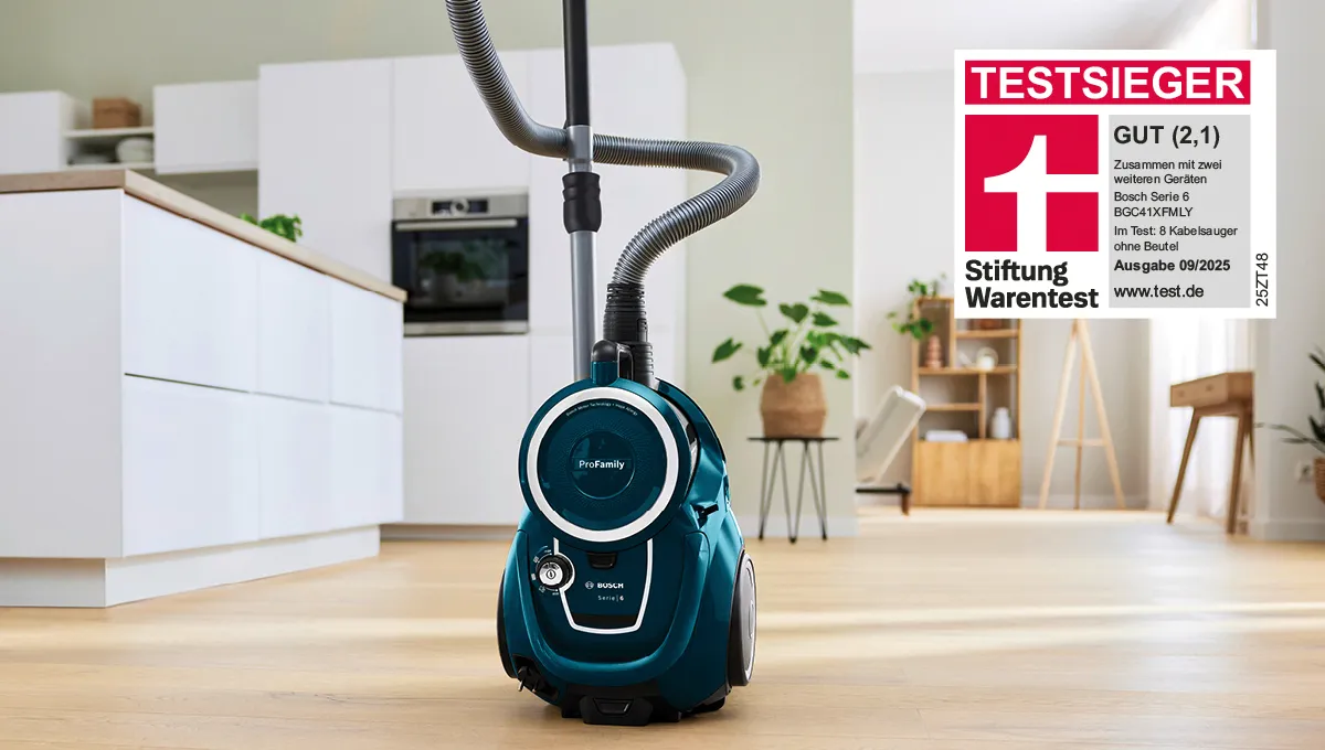 Ein blauer, beutelloser Serie 6 Staubsauger von Bosch steht auf dem Küchenboden und wurde mit der Bestnote GUT (2,1) Testsieger der Stiftung Warentest 09/2025.