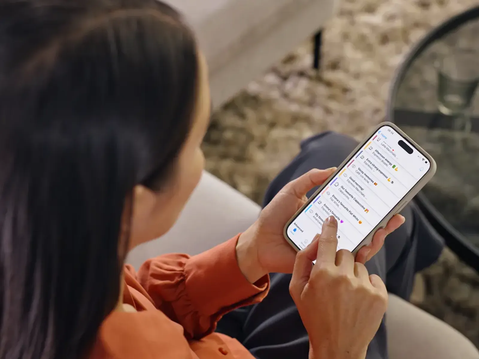 Överblick av en kvinna som interagerar med Siemens Home Appliances-appen på en smartphone.