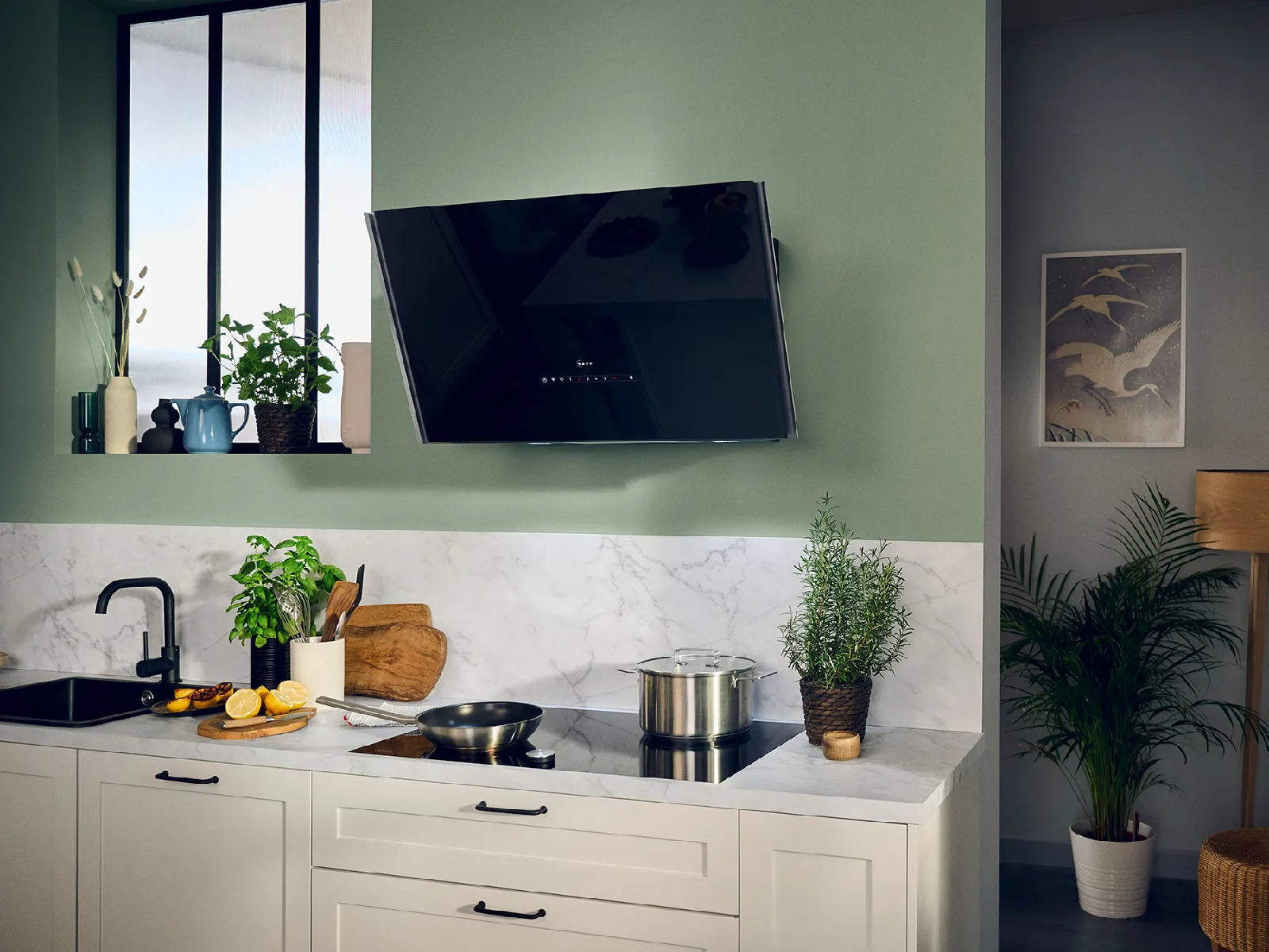 A modern kitchen with a gas hob and an elegant black hood.