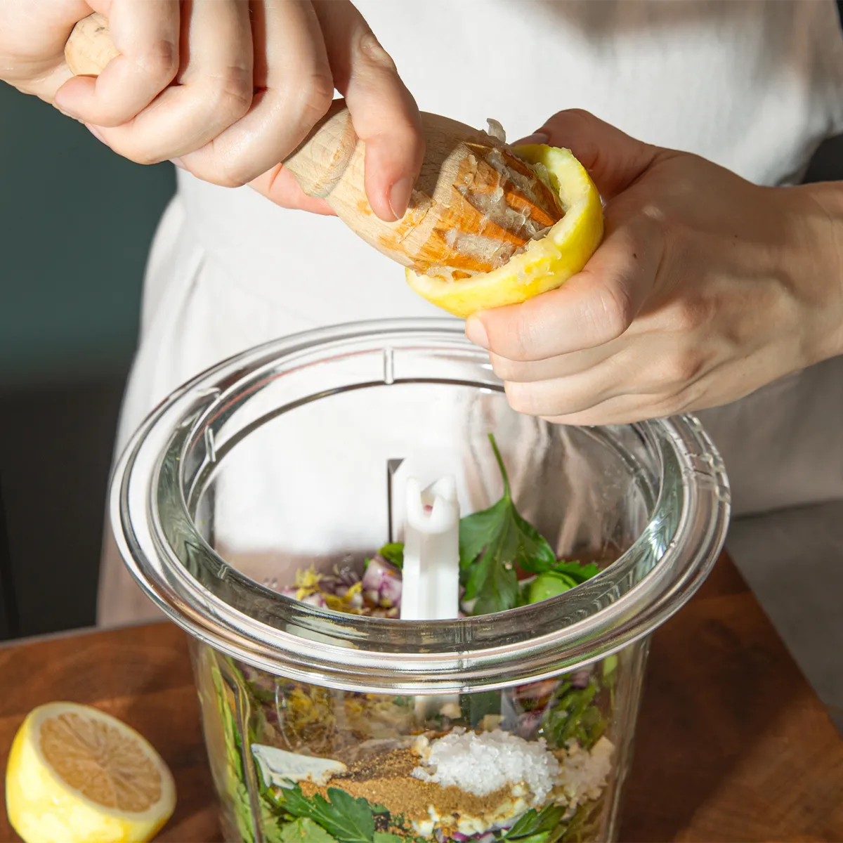 Adding the zest of half a lemon in a food processor filled with ingredients