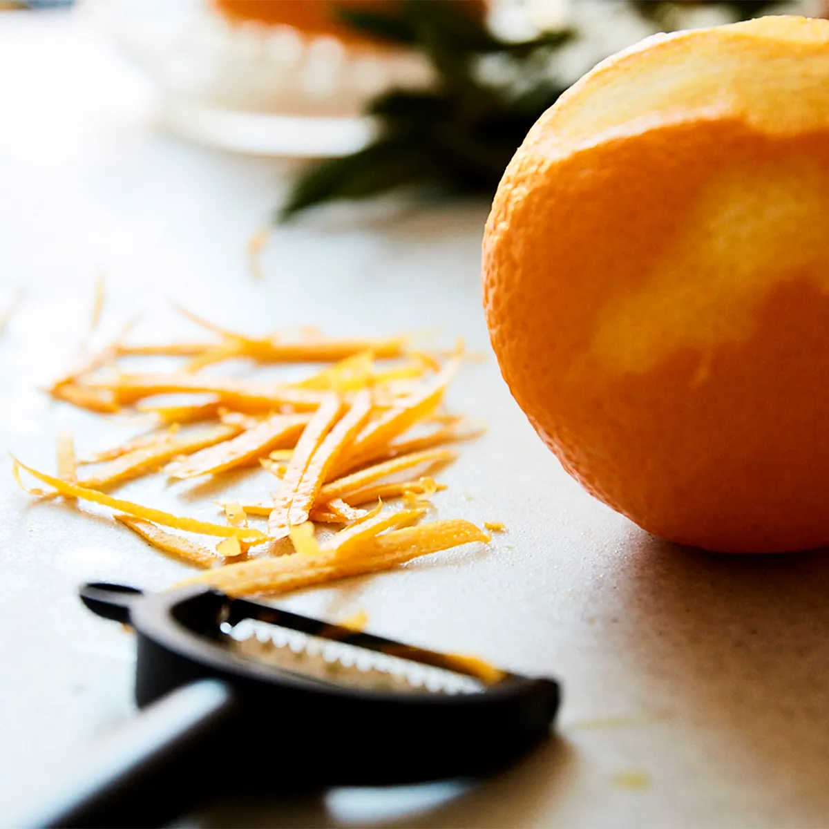 Fresh orange being zested with a peeler. Bright citrus flavor for a Neff recipe.