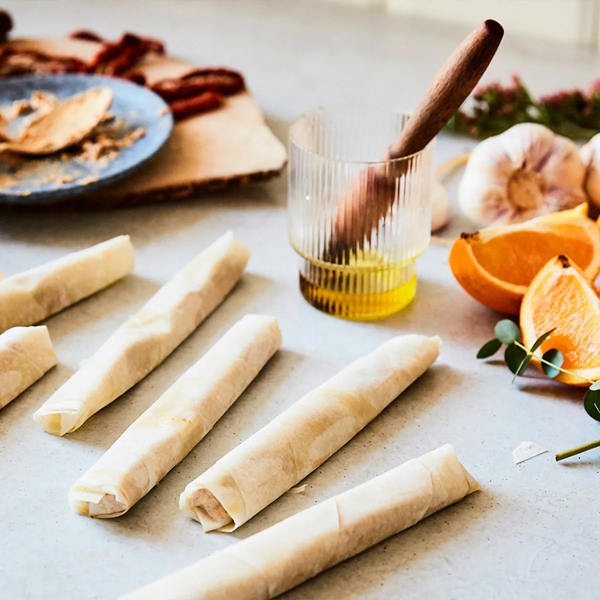 Delicate phyllo rolls with fresh oranges, garlic, and olive oil, ready for cooking. Neff inspires delicious homemade meals.