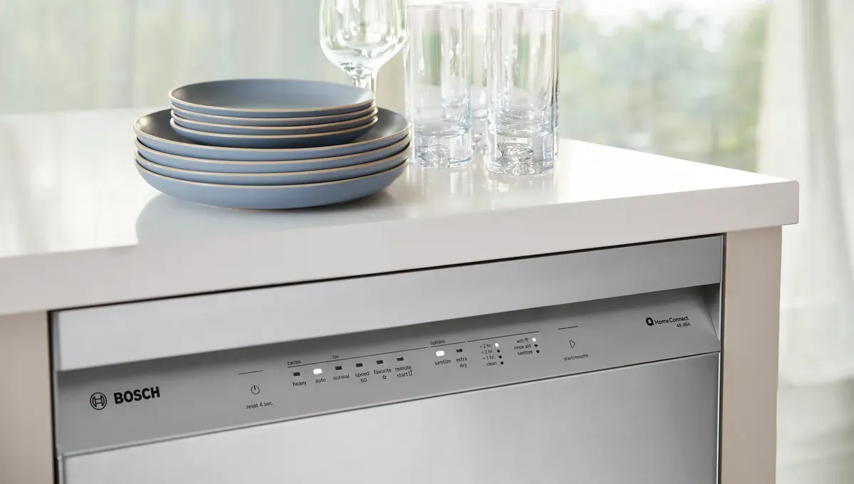 Bosch dishwasher closed with clean dishes on counter