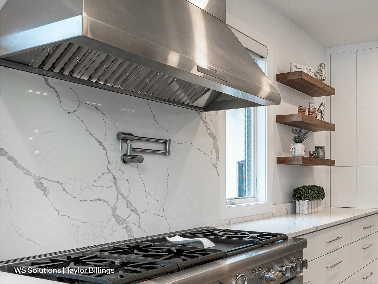 Thermador HPCN48WS 48-inch professional pyramid chimney wall hood over a marble backsplash.