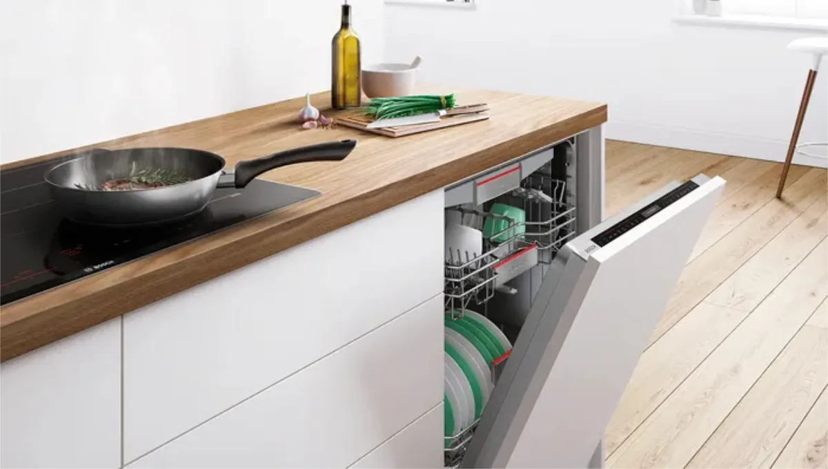 Modernt kök med träbänk, diskmaskin, matlagningsredskap och minimalistisk inredning.