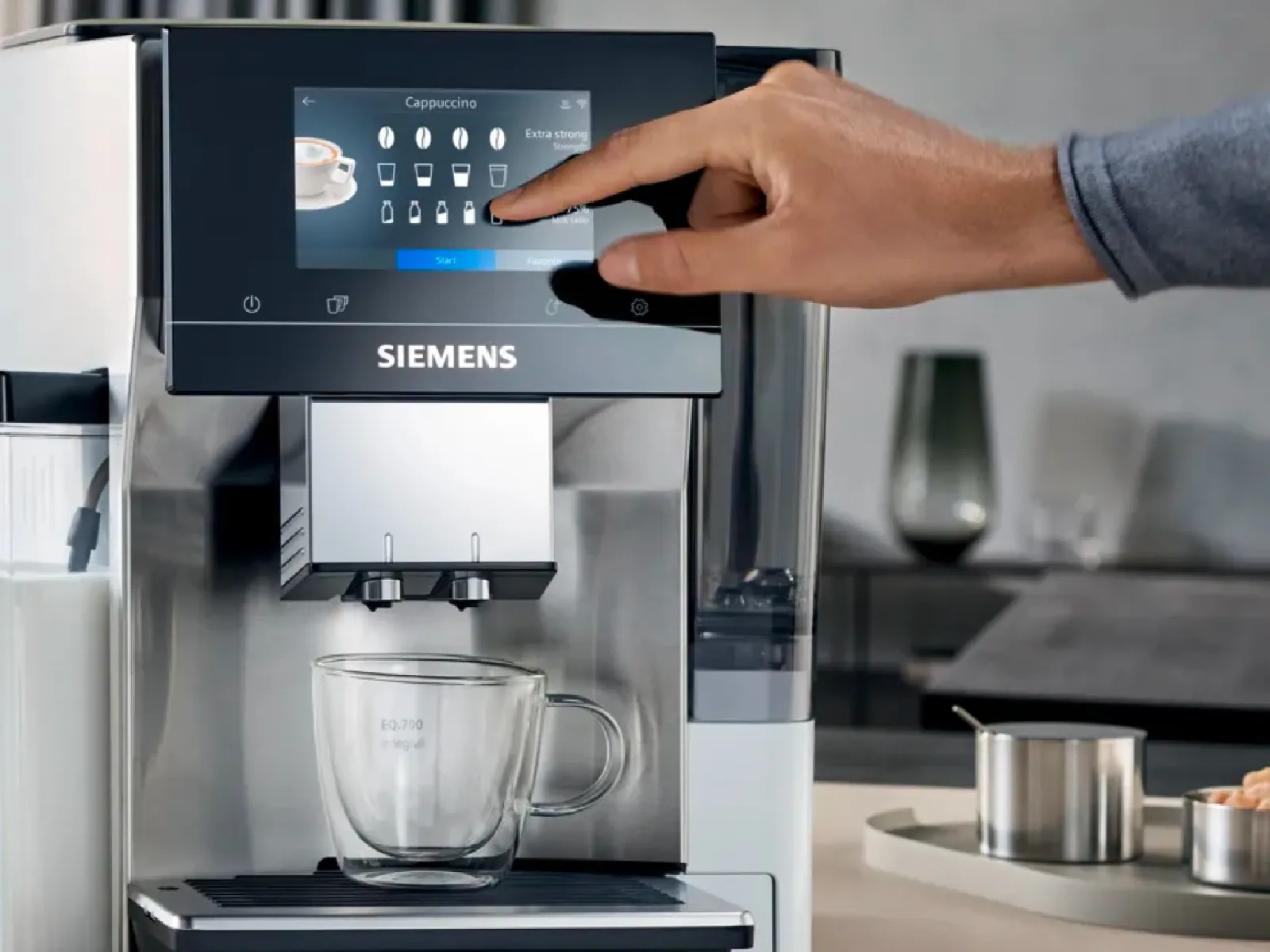 Siemens kafijas automāts, kura vadības panelī ir manuāli nospiežamas pogas mūsdienīgā virtuvē.