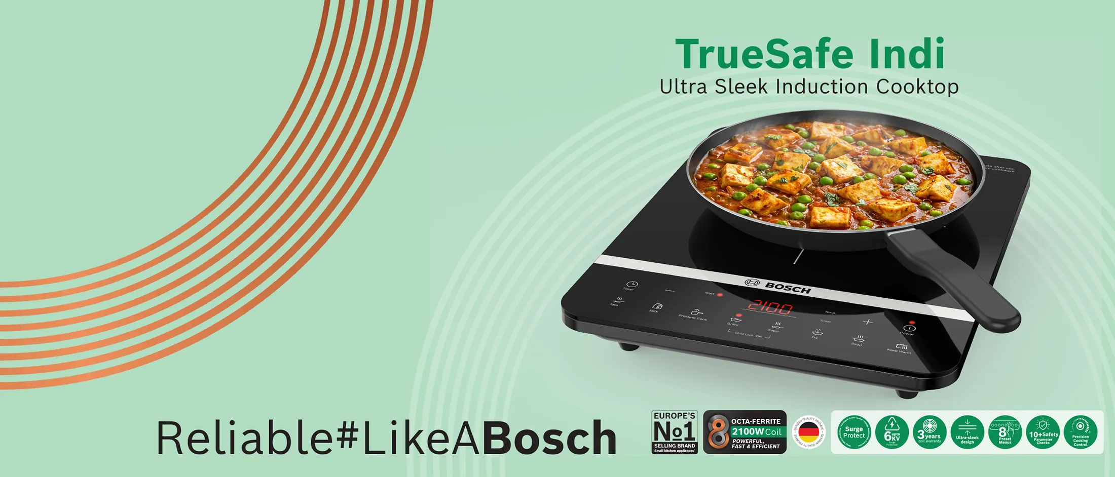 A black Bosch air fryer on a wooden kitchen counter surrounded by fresh vegetables.