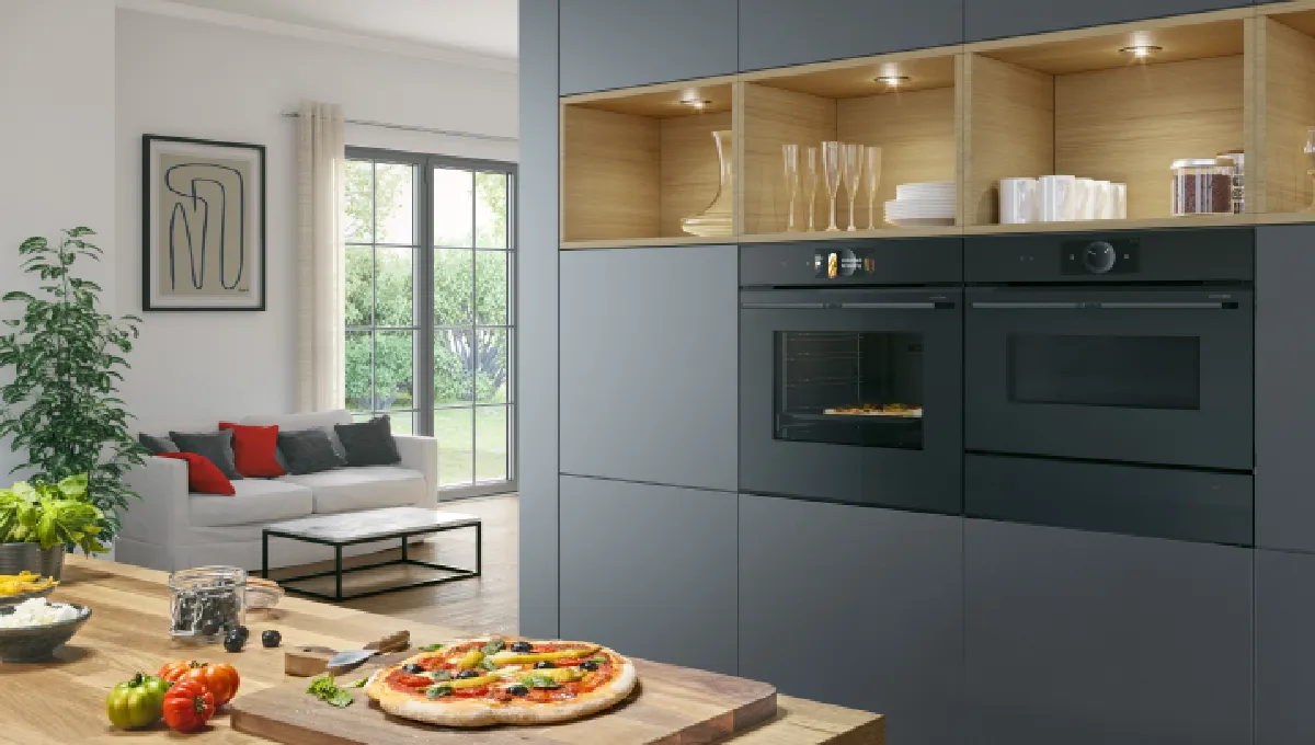 Moderne kjøkken med stilrene svarte skap, benkeplate i tre, pizzaovn og sittegruppe.
