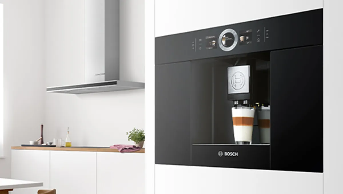 Moderne kjøkken med innebygd Bosch-kaffemaskin, benkeplate i tre og minimalistisk design.