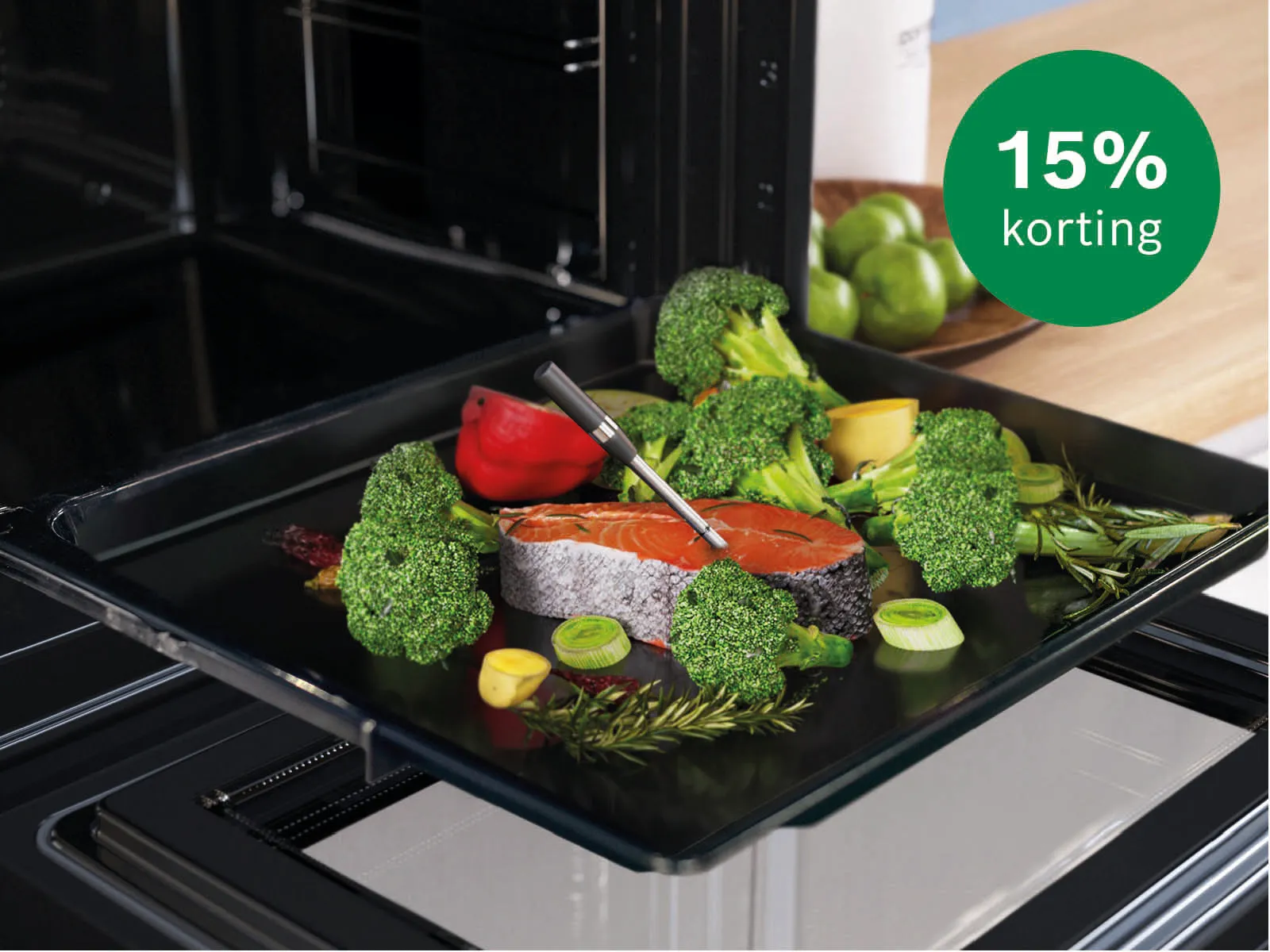 Openstaande oven met bakplaat met daarop zalm en groene groente met kerntemperatuurmeter