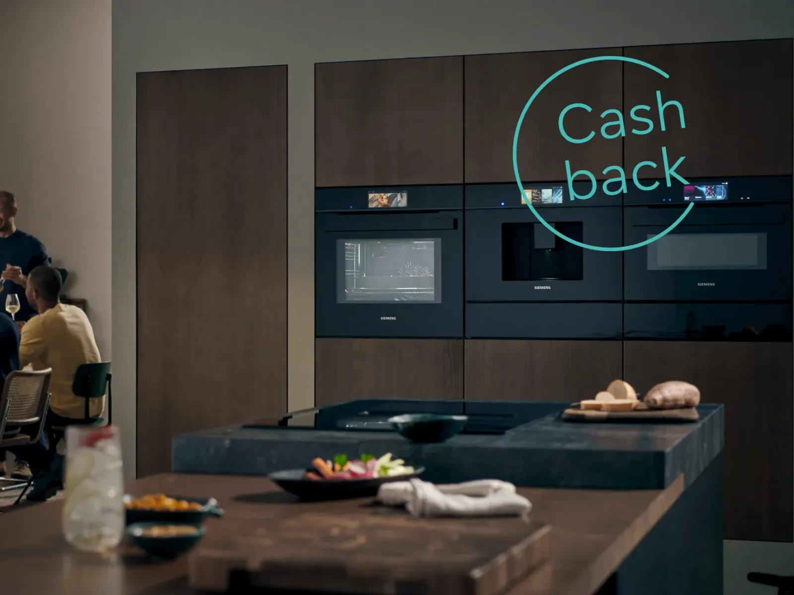 Et moderne køkken med stilrene studioLine-apparater, en træbænk med forberedte retter og et cashback-tilbud, der vises tydeligt.