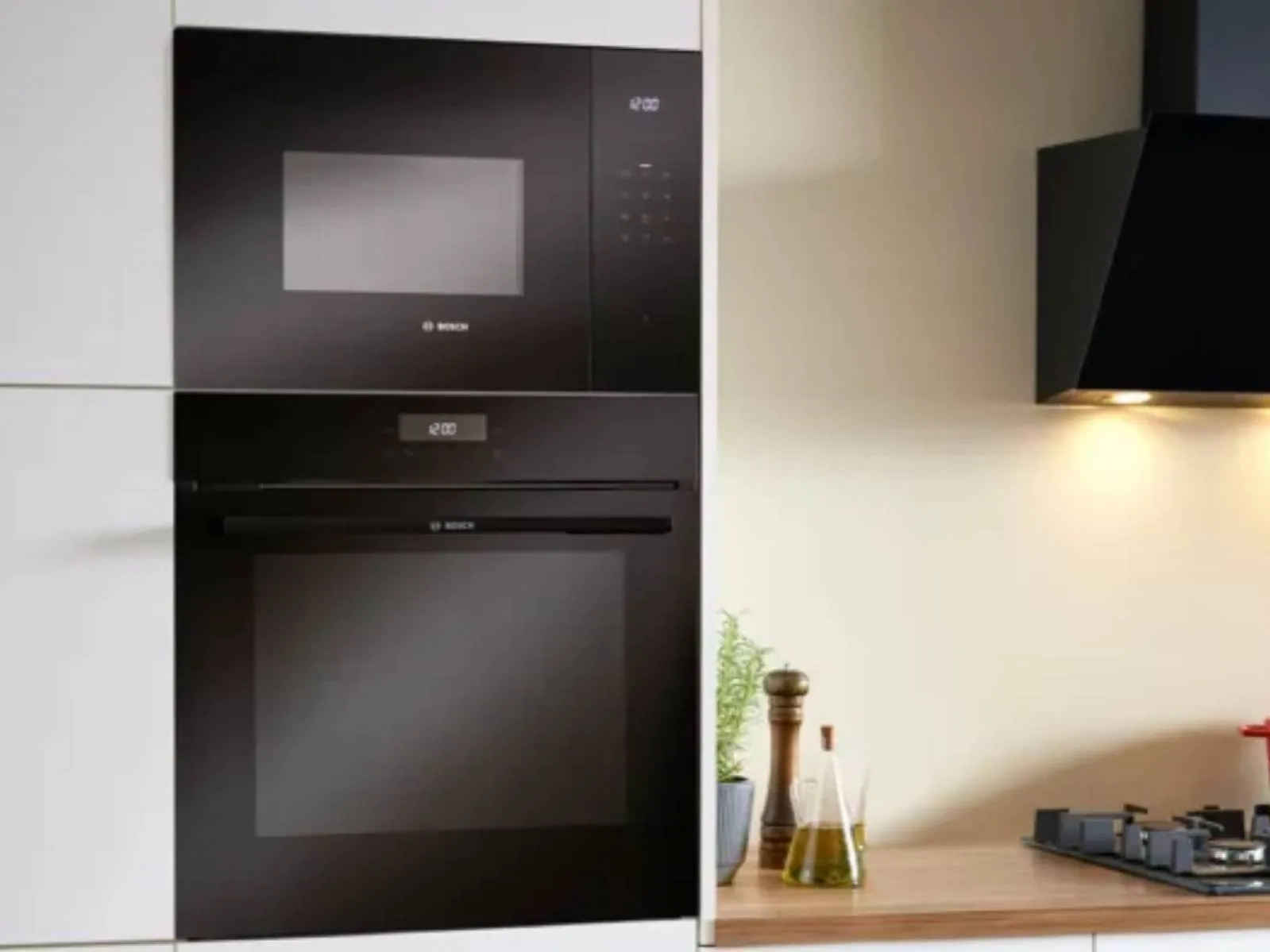 A modern Bosch oven and microwave combo in elegant black, highlighted by a minimalist kitchen with chic wood accents.