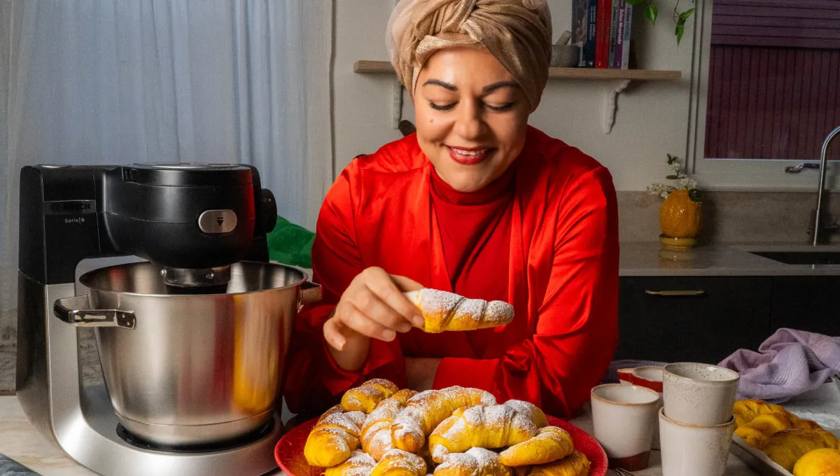 Julstämning i kök med Zeina och saffransgifflar. Hon har på sig en röd vacker julblus.