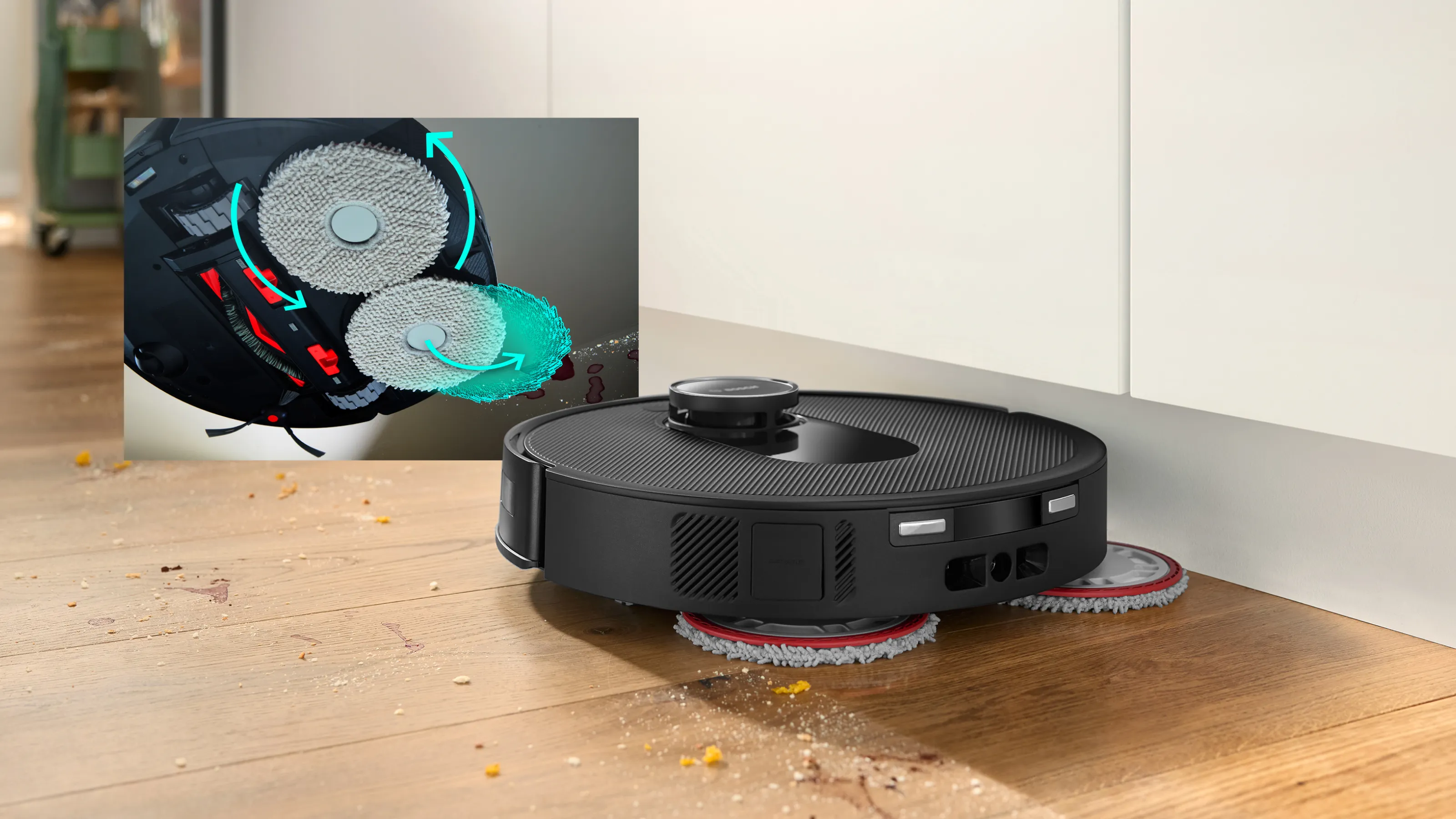 Robot usisavač s dvije rotirajuće krpe čisti drveni pod blizu zidnog kuta, s umetakom koji prikazuje krpe i spremnik za vodu izbliza