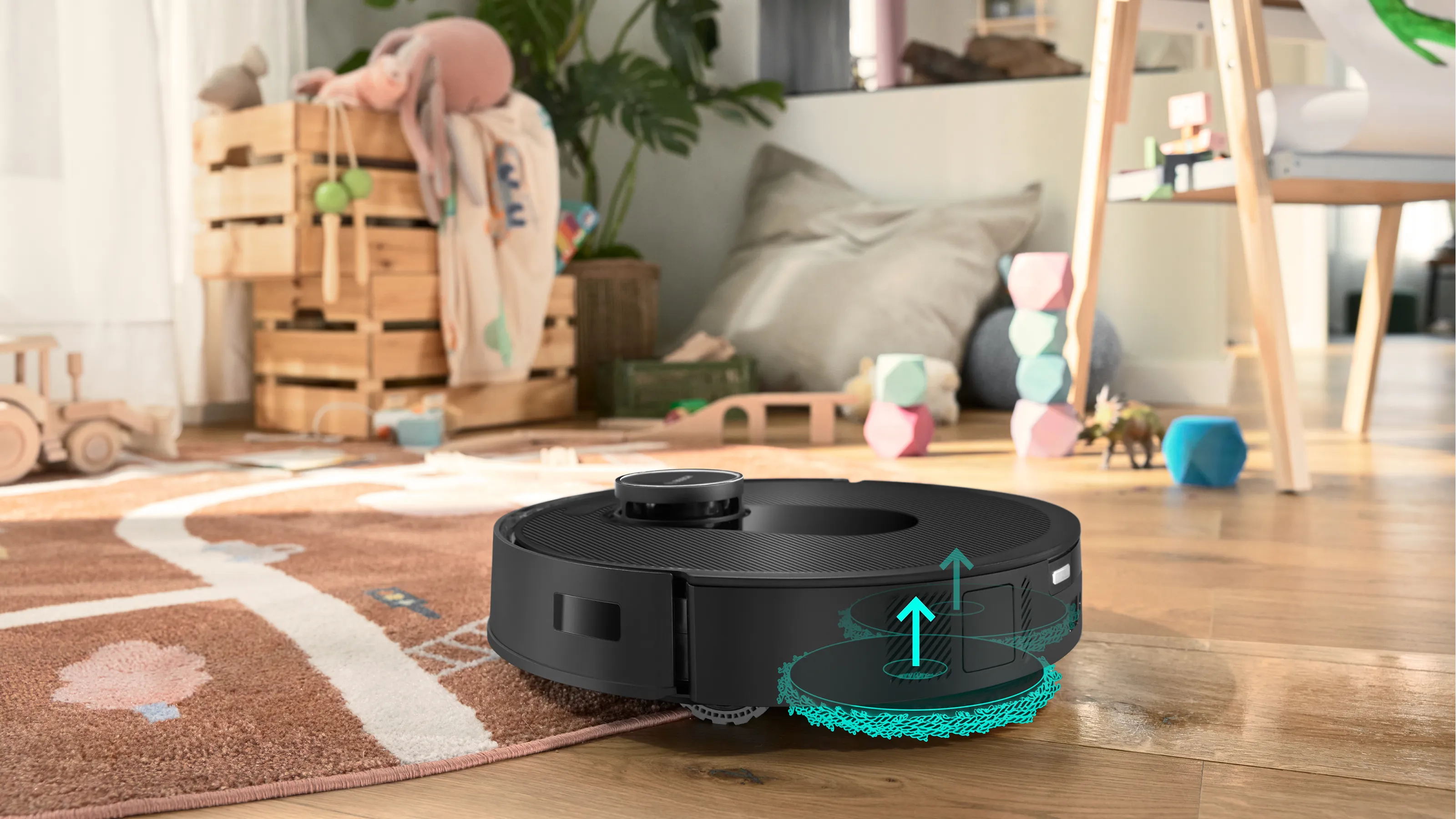 Okrugli robotski usisavač s tirkiznom četkom ispod na tepihu u dnevnoj sobi