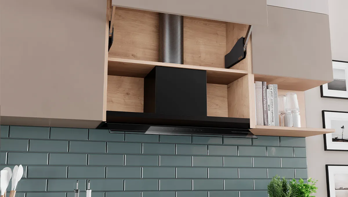 Cappa da cucina a incasso all'interno di un mobile in legno, sopra un'alzatina di piastrelle verdi.