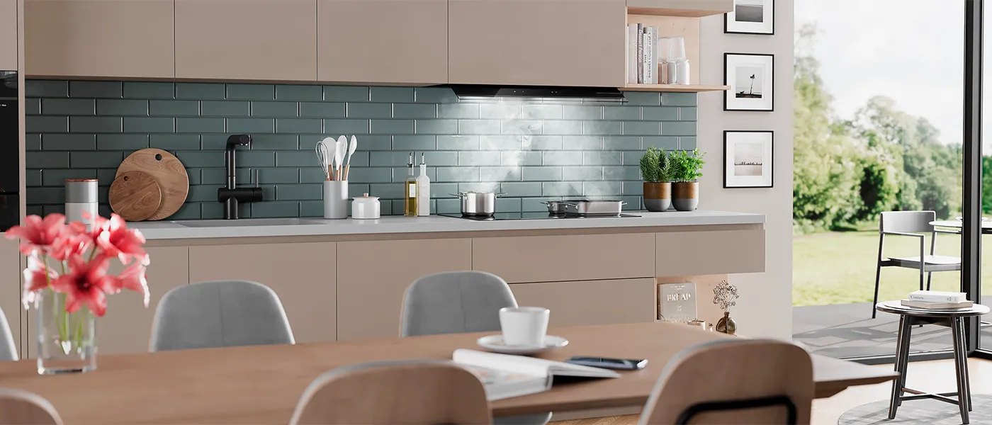 Cucina moderna con mobili in legno chiaro, alzatina in piastrelle color foglia di tè e tavolo da pranzo con fiori.