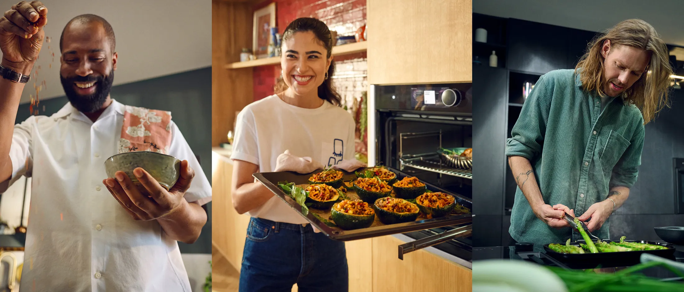 three people cooking in three kitchens: left panel — a smiling bearded man in a white short-sleeve shirt with a patterned towel over his shoulder sprinkles spices into a ceramic bowl; center — a smiling woman in a white T-shirt and jeans holds a baking tray of stuffed squash halves just out of the oven; right — a long-haired person in a green button-up shirt stands at a stovetop, tending a pan of asparagus.