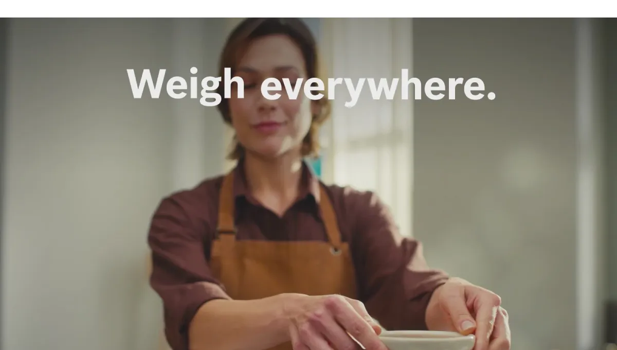 A woman standing in front of a Bosch kitchen machine Series 8.