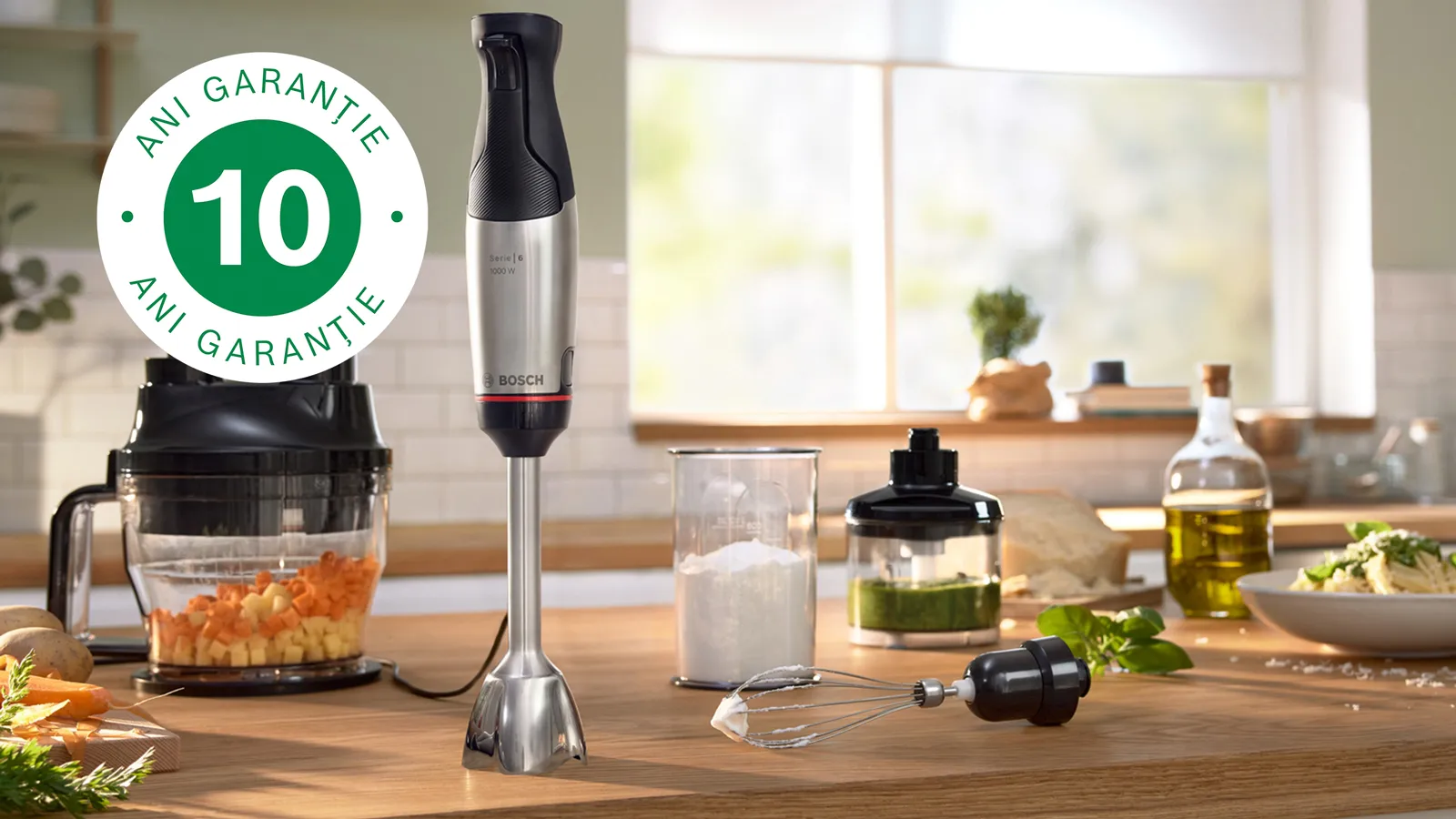 Blender de mână pe un blat de bucătărie alături de diverse ingrediente si accesorii și logo "10 ani garanție"
