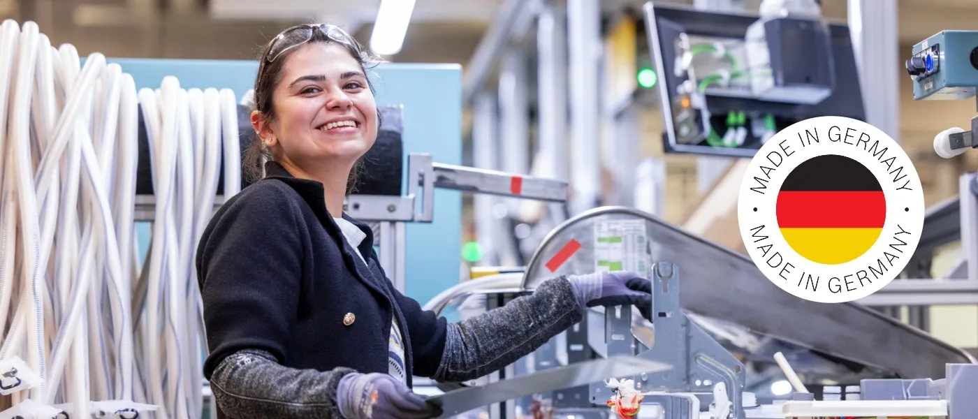 Bosch employee in one of Bosch's dishwasher factories, smiling at the camera, with a Made in Germany logo integrated.