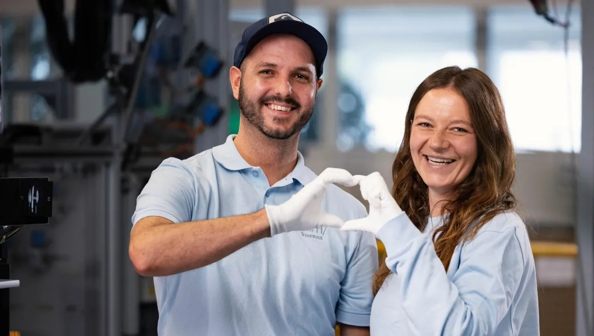 Two employees in the Bosch factory in Traunreut forming a heart shape in the air with their hands.