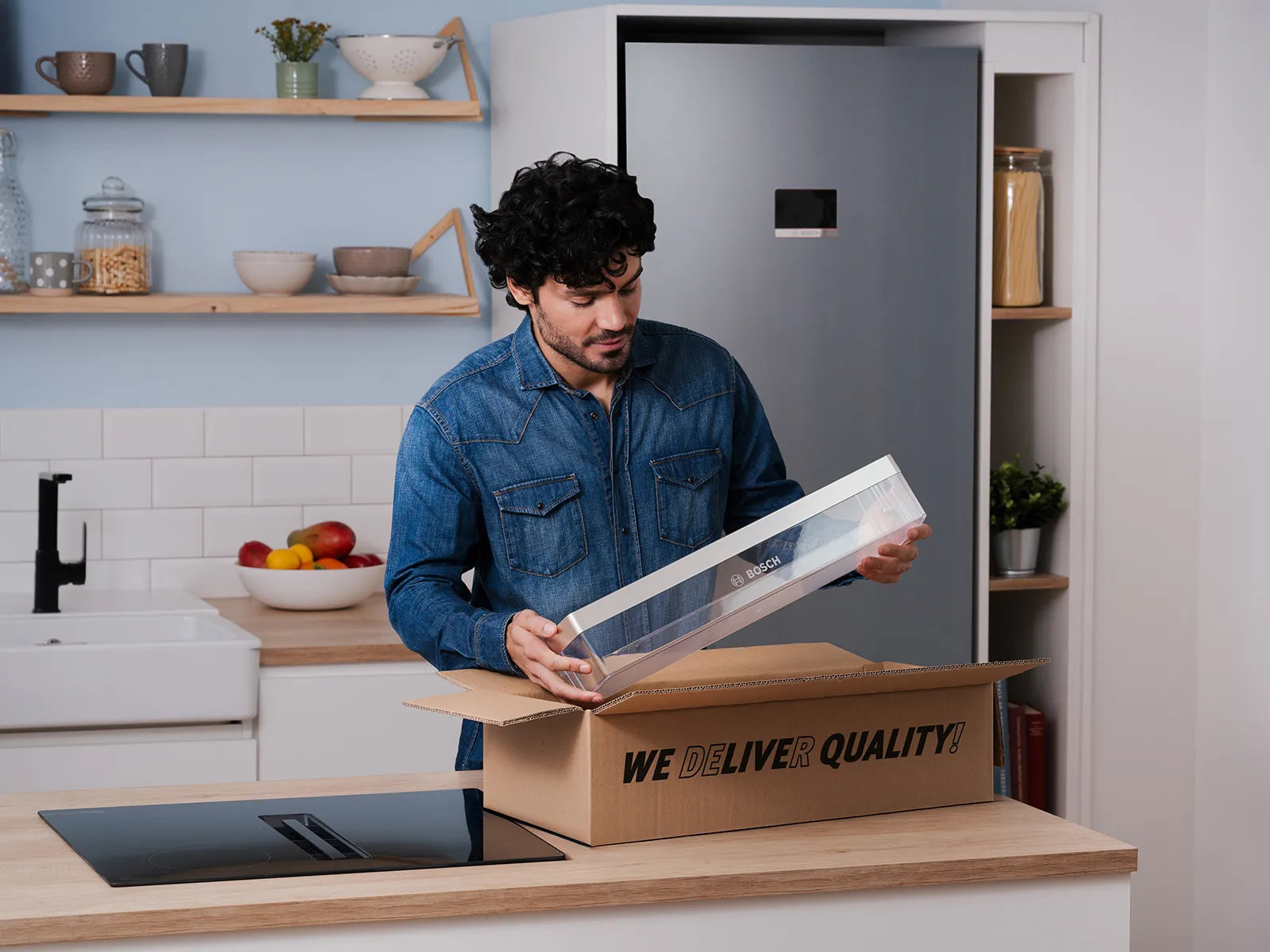 Un homme déballe une pièce de rechange Bosch dans sa cuisine