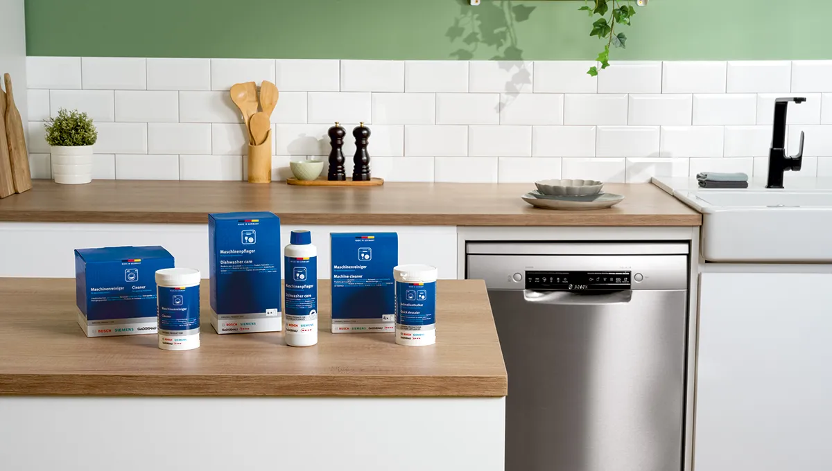 Des produits d'entretien Bosch posés sur une étagère devant un lave-vaisselle