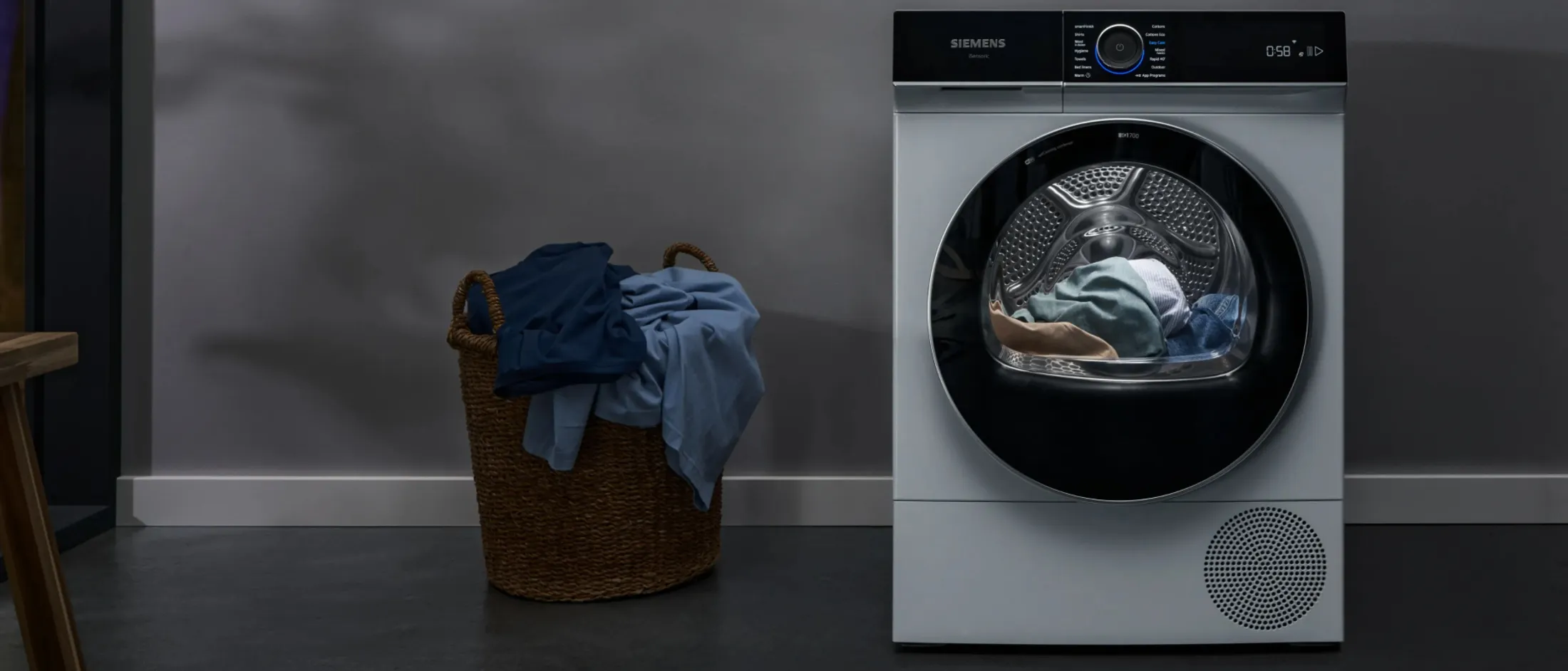 Vue avant d'un sèche-linge Siemens avec vêtements à l'intérieur, logos Red Dot et IF Design Awards 2023 en haut.