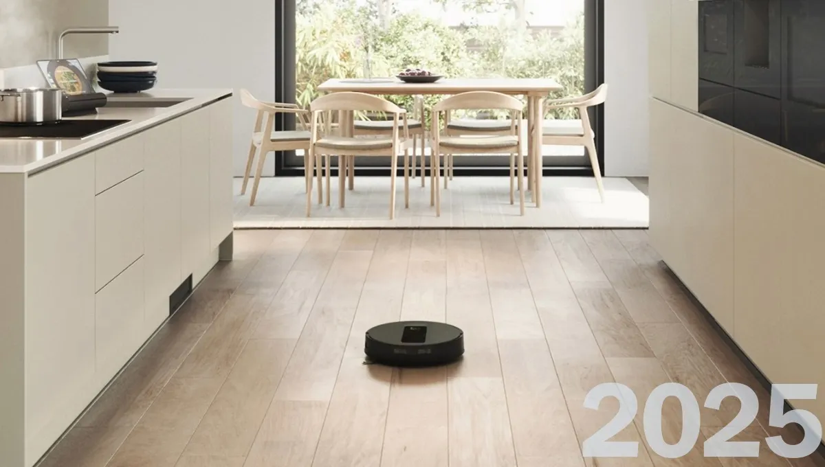 Bosch built-in vacuum and mop robot on a kitchen floor in a modern home, the year 2025 marked in the bottom right corner.