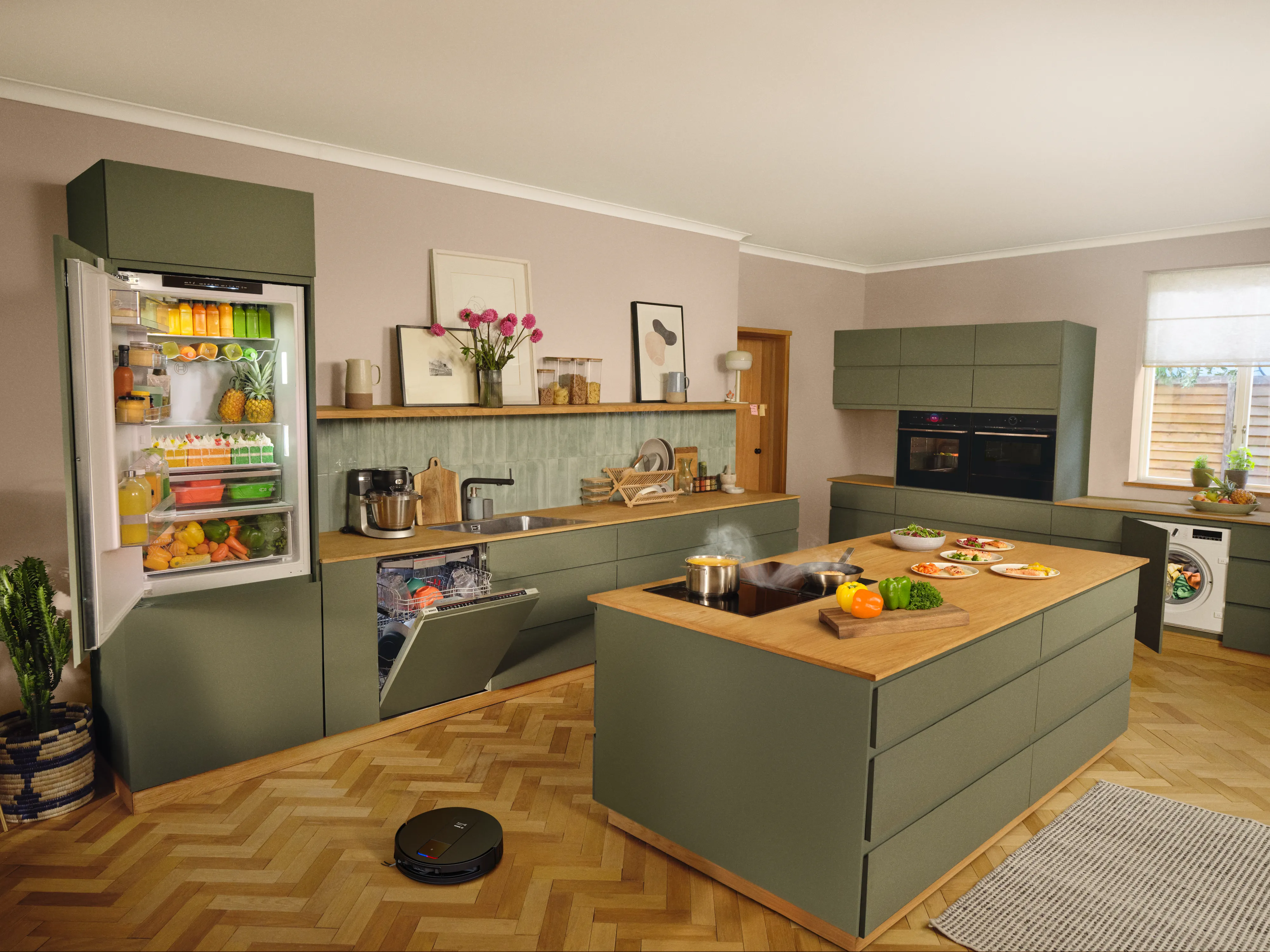Imagen de cocina abierta al salón con tonos verdes y frigorífico abierto