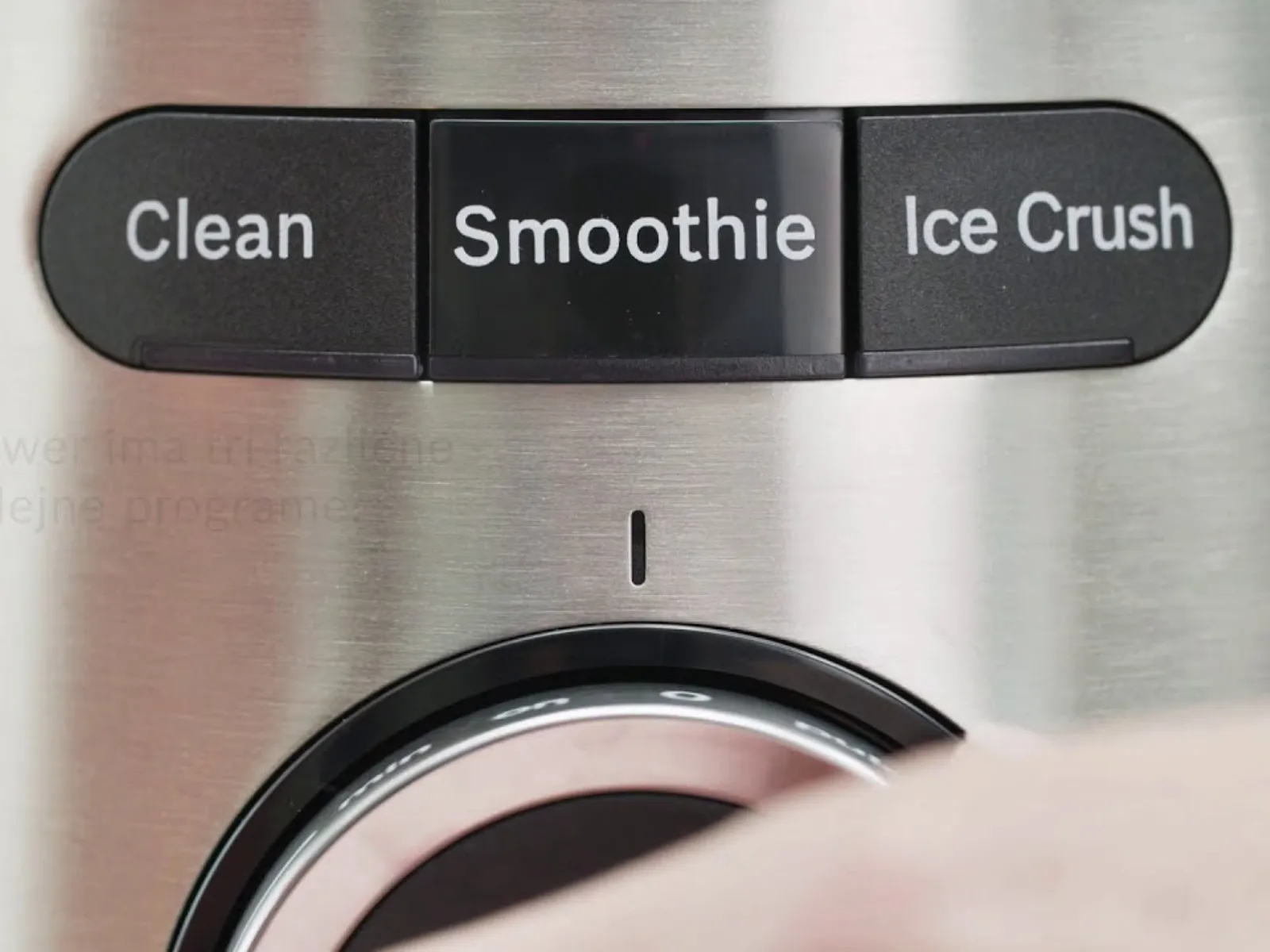 Približek nadzorne plošče mešalnika z gumbi z napisom »Clean«, »Smoothie« in »Ice Crush« nad vrtljivim gumbom