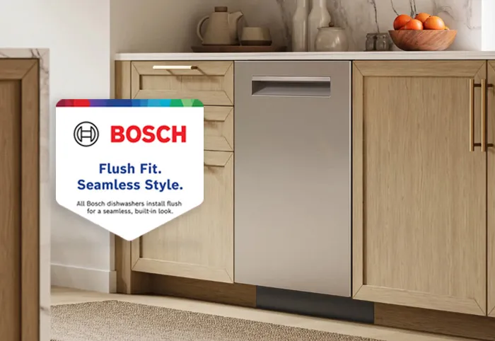 Bosch stainless steel dishwasher seamlessly integrated into light wood kitchen cabinetry with modern countertop decor.