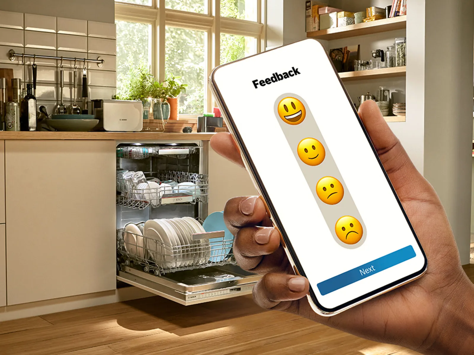 Smartphonescherm met feedbackenquête en emoji-iconen, apparaat in de hand in een keuken.