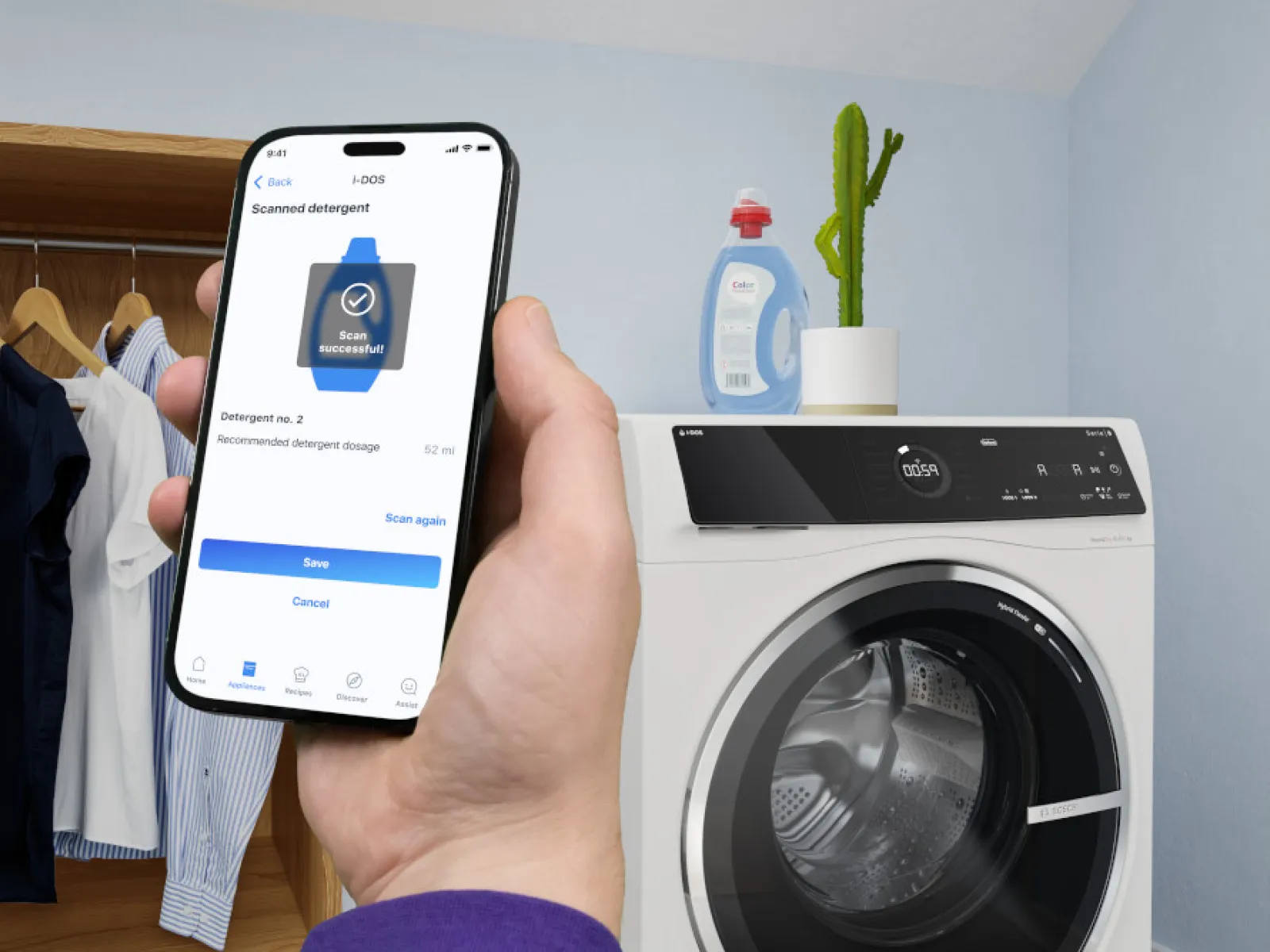 Smartphone scant wasmiddelfles, wasmachine en huishoudelijke artikelen op de achtergrond.