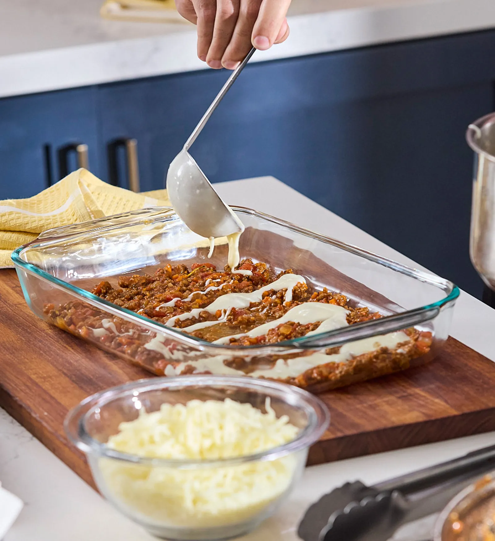 Chef applying bechamel sauce on lasagna