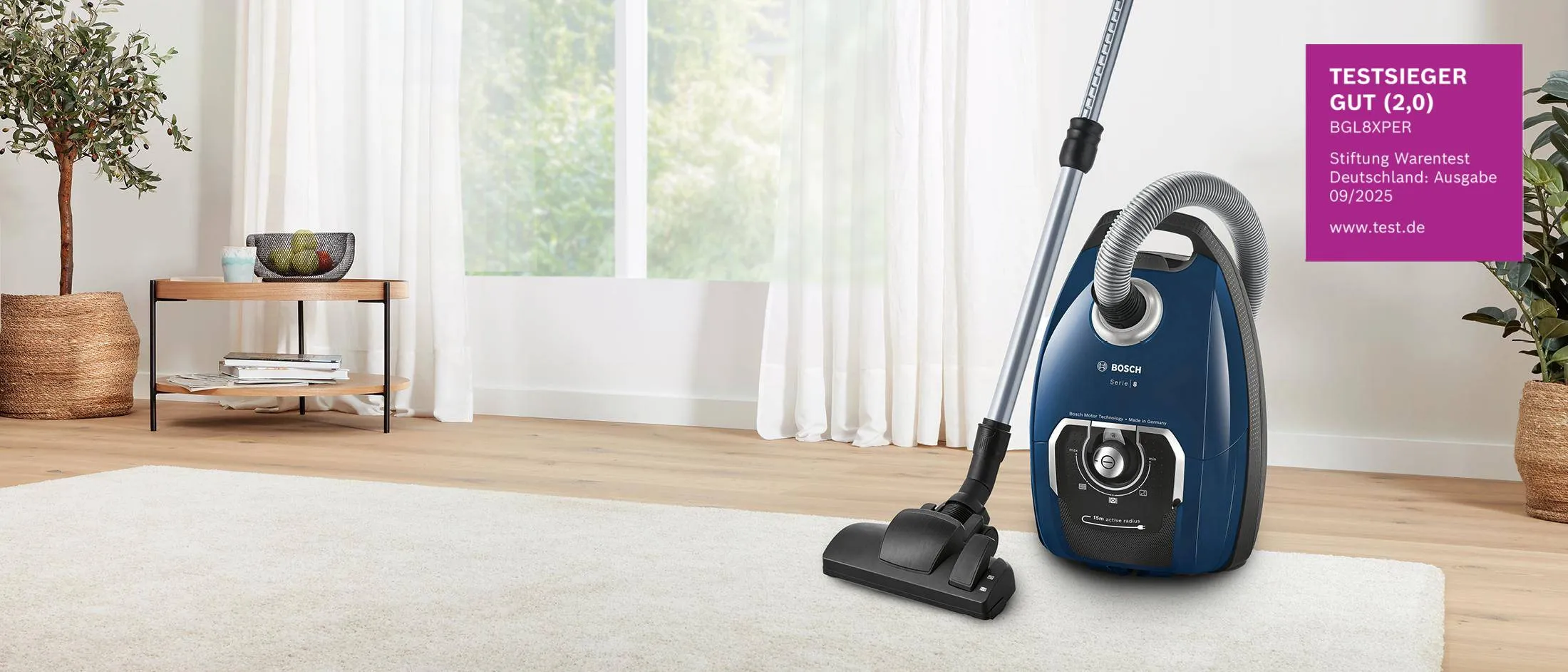 Bosch Serie 8 Staubsauger mit Beutel im Wohnzimmer mit Stiftung-Warentest-Testsieger-Siegel.