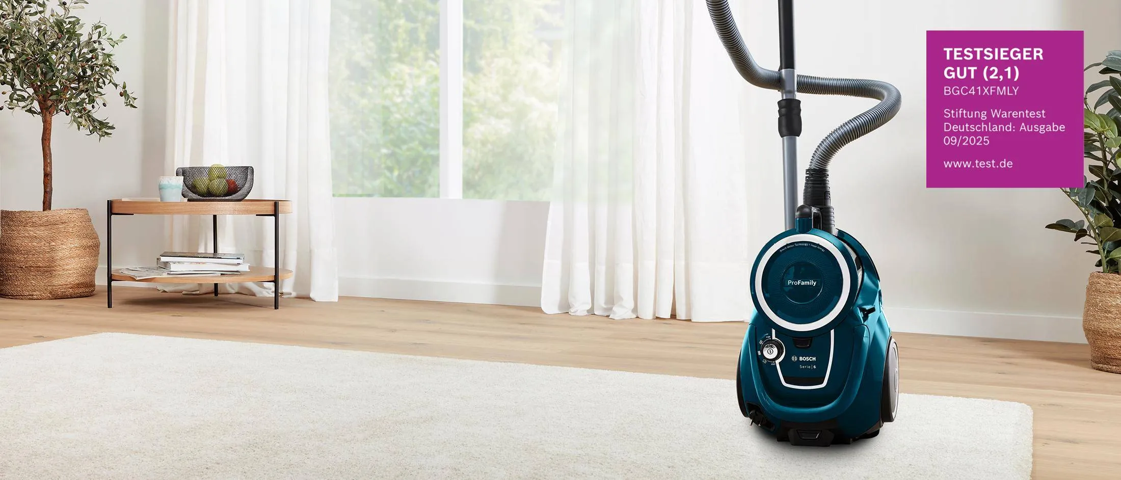 Bosch Serie 6 ProFamily Staubsauger ohne Beutel im Wohnzimmer mit Stiftung-Warentest-Testsieger-Siegel.