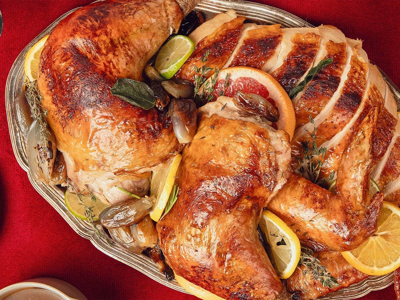 Carved up lemon and thyme roast turkey with golden skin on a serving platter in a festive christmas setting