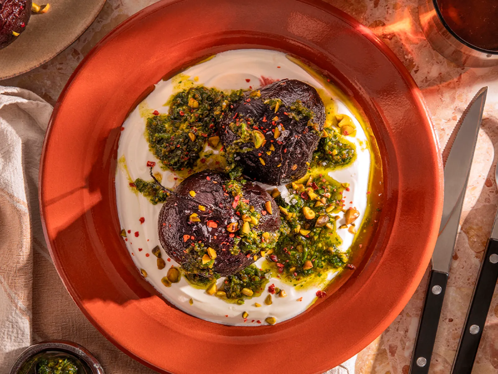 Vibrant roasted beets with creamy yogurt, fresh pesto, and crunchy pistachios, beautifully plated. A delicious and healthy meal.