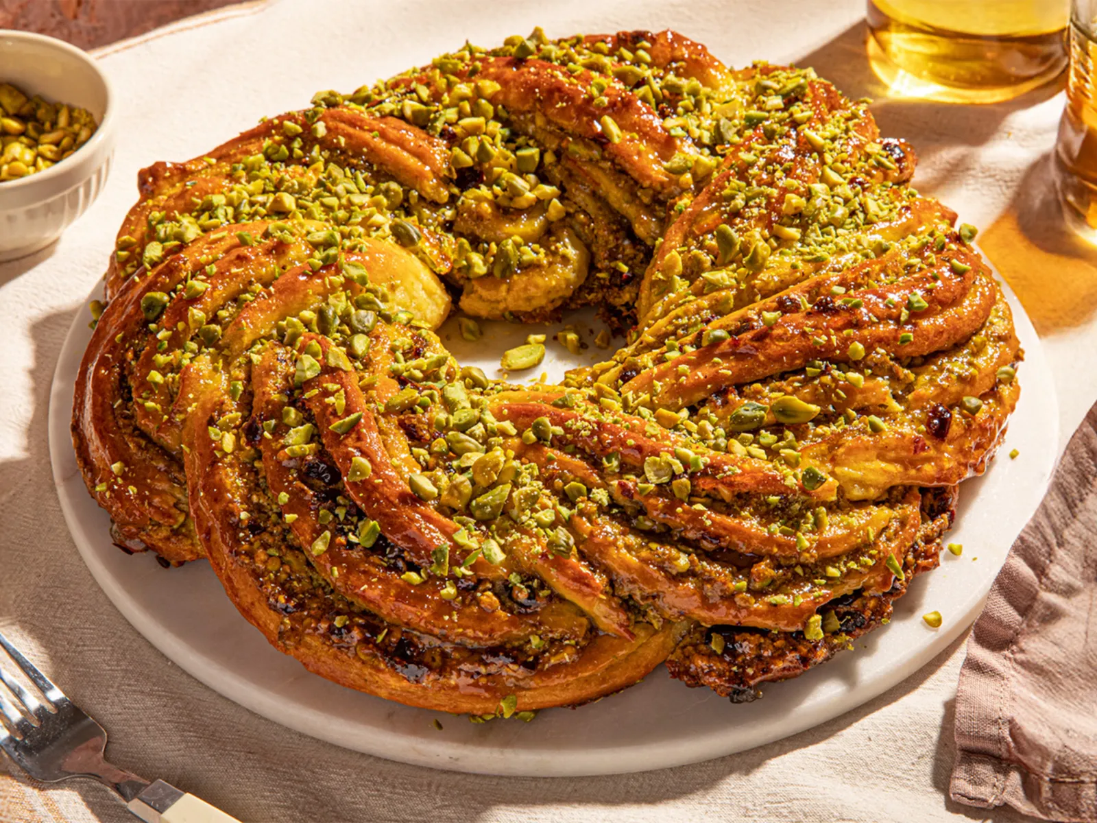 Golden brown baked braided Easter bread with pistachio and cranberry filling formed like a wreath.
