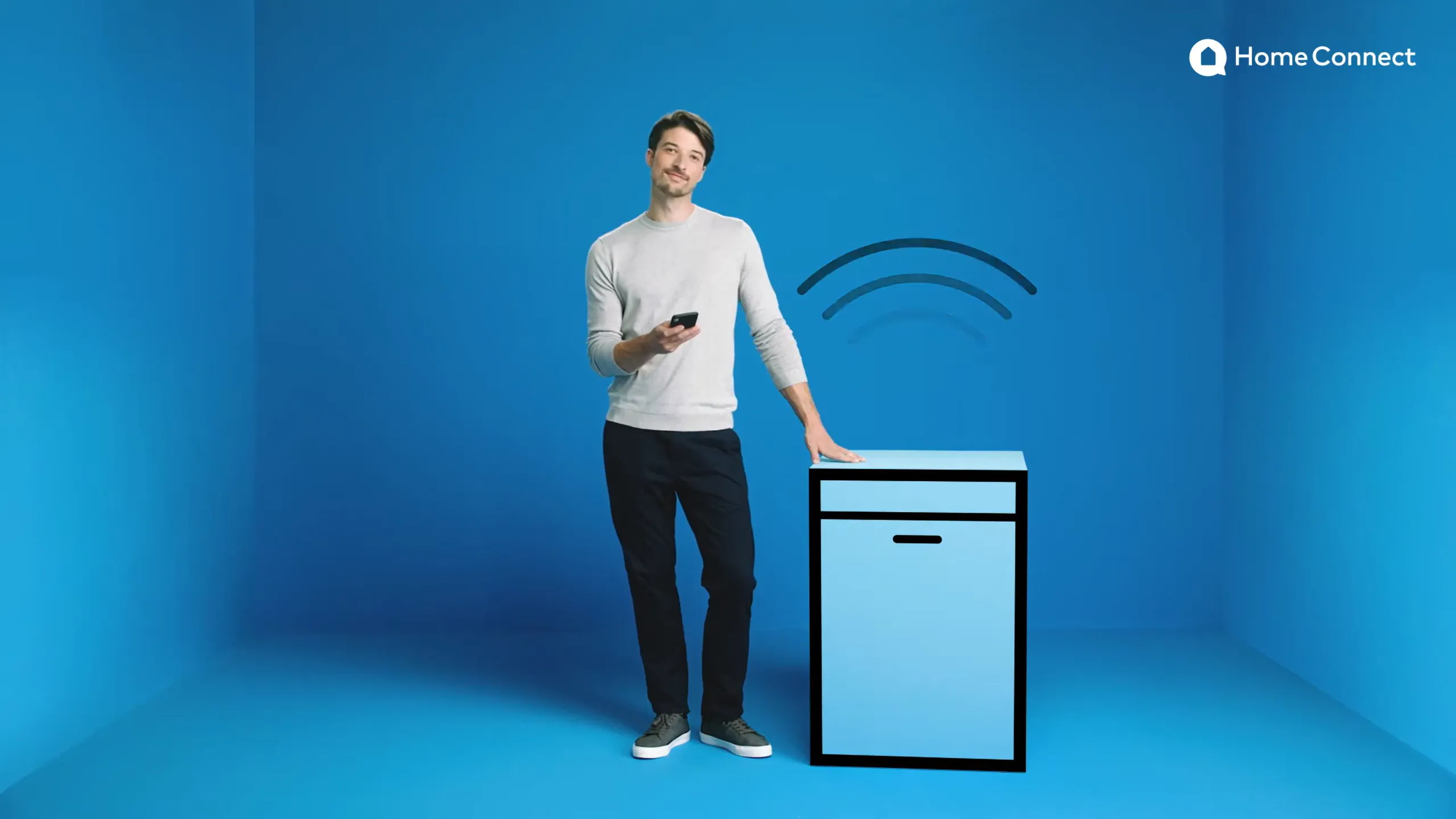 man standing in a blue room while holding a smartphone
